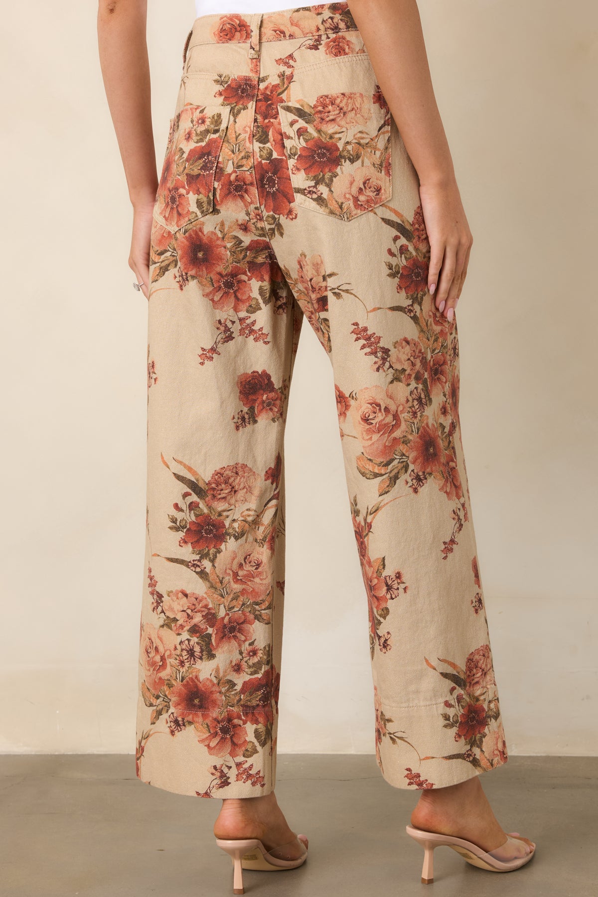 Rear of the taupe floral pants showcasing the high-rise waist, rear patch pockets, and cropped wide-leg silhouette.