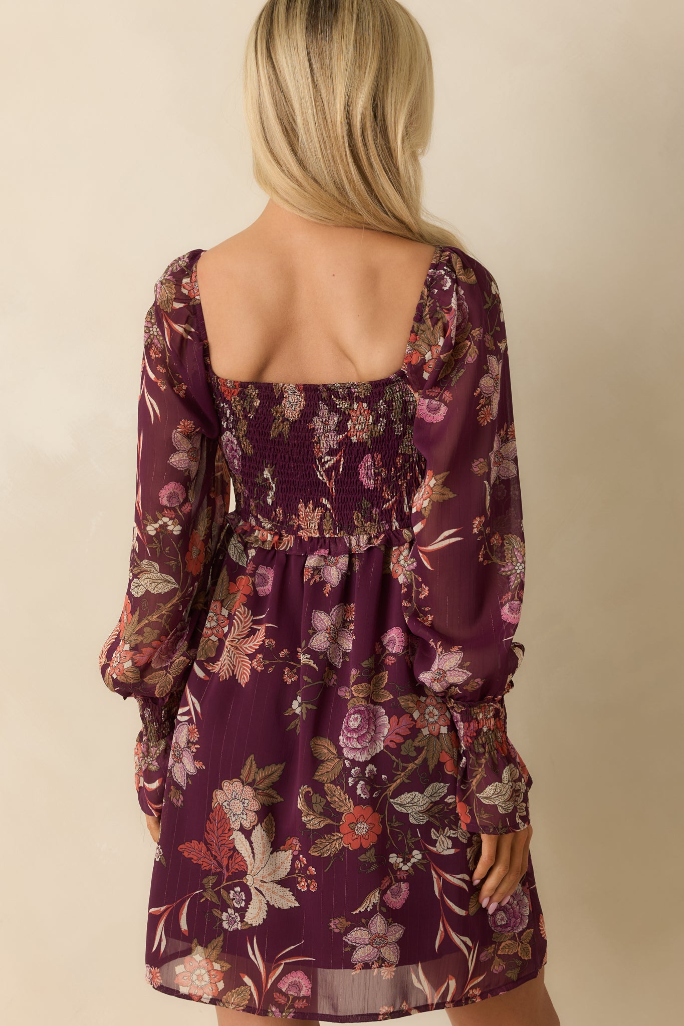 Rear view of berry purple floral mini dress showing smooth back and A-line skirt.