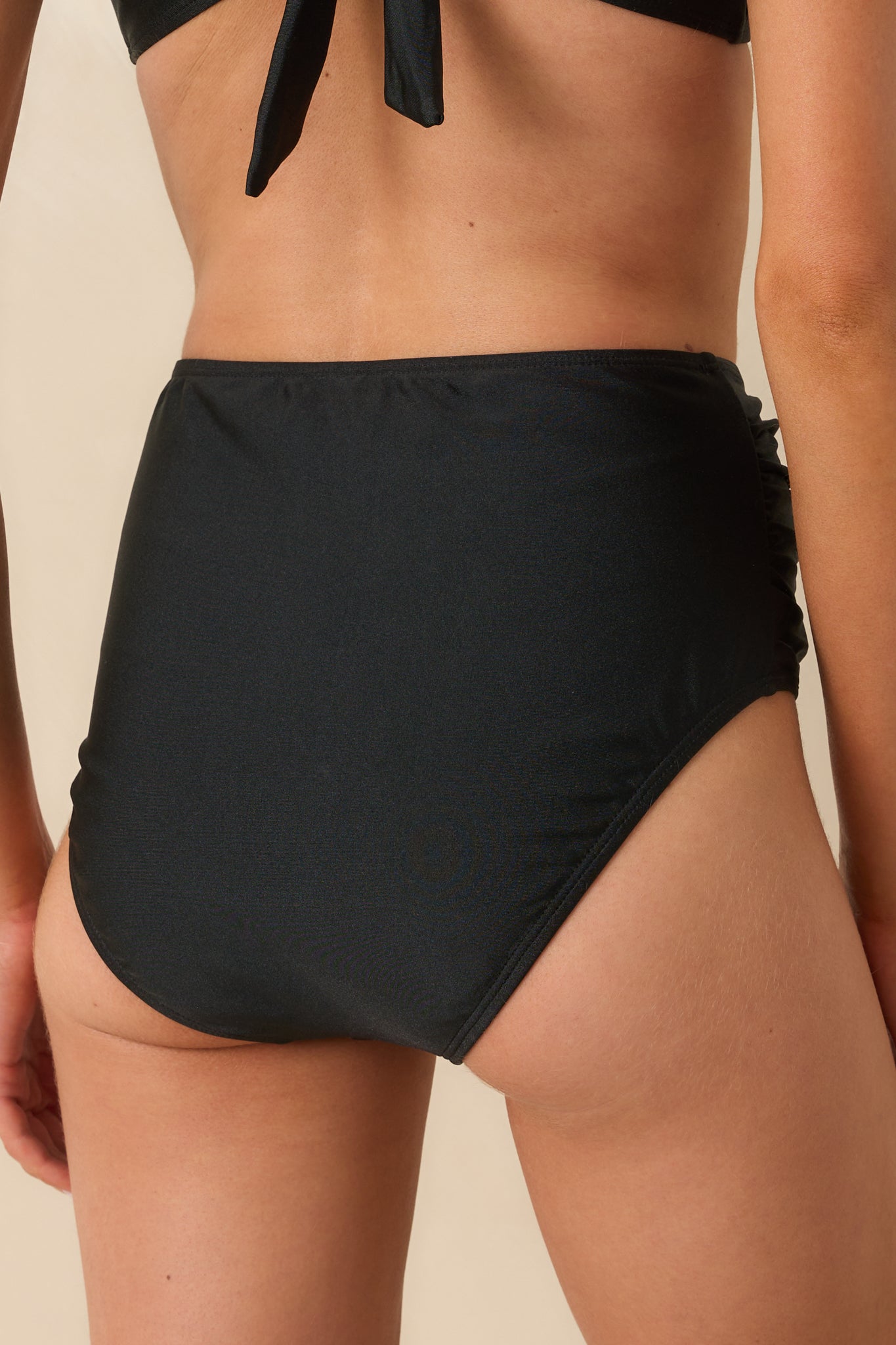 Rear view of the black bikini bottoms displaying the medium-full back coverage and the seamless waistband finish.