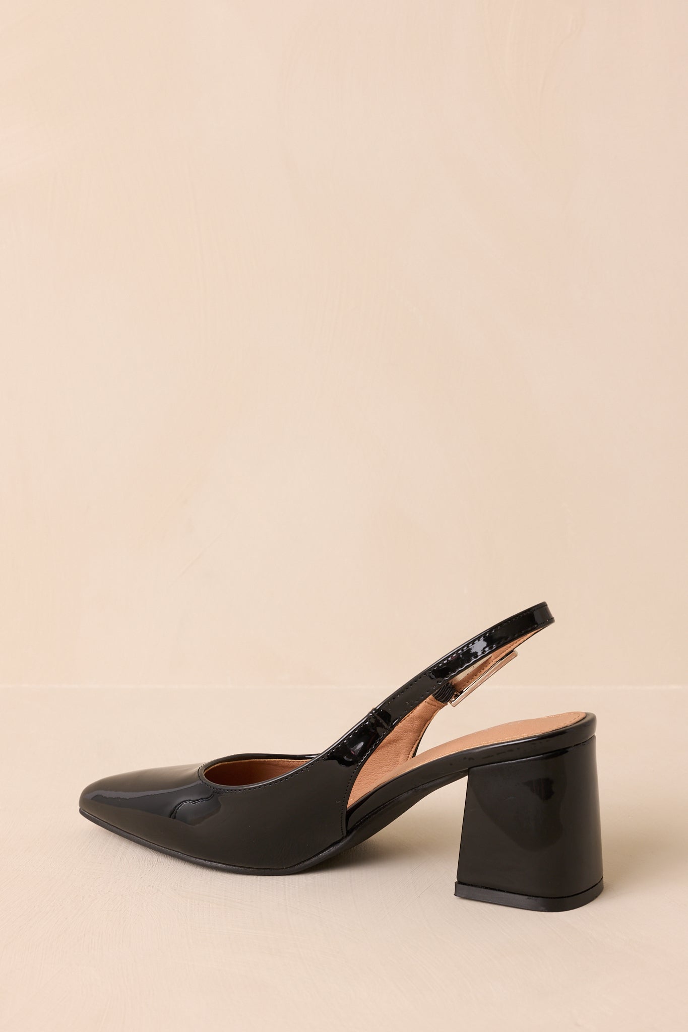 Rear view of black heels highlighting block heel and slingback strap.