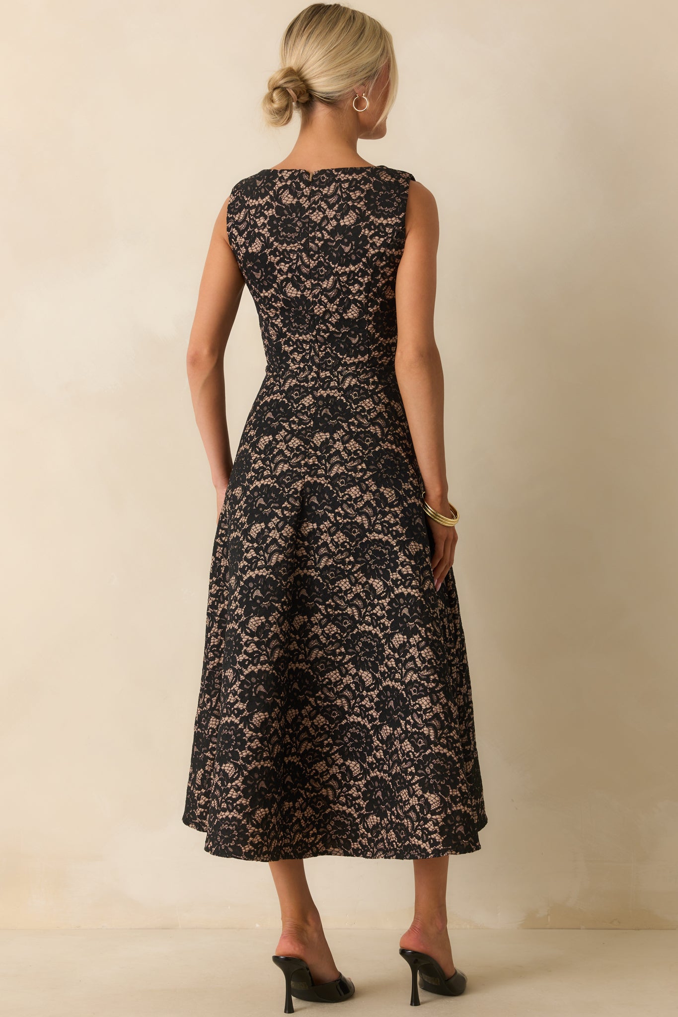 Rear view of the black lace midi dress with hidden zipper closure and flowing A-line skirt.