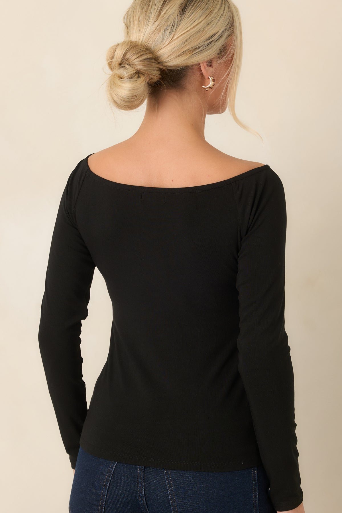 Rear view of the black stretch top showing its smooth close-fitting silhouette and long sleeves.