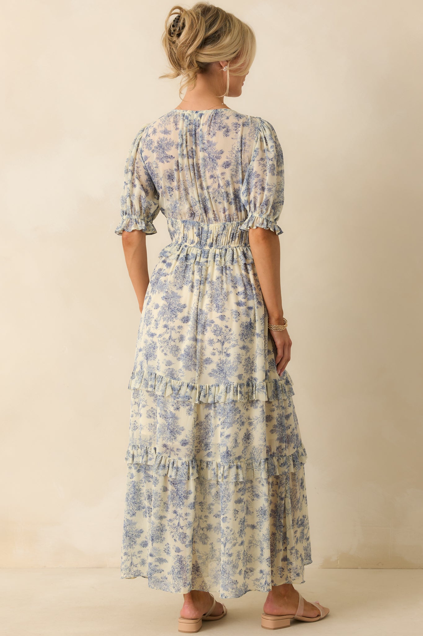 Rear view of the blue maxi dress with tiered skirt, showing the puff sleeves and gathered elastic cuffs.