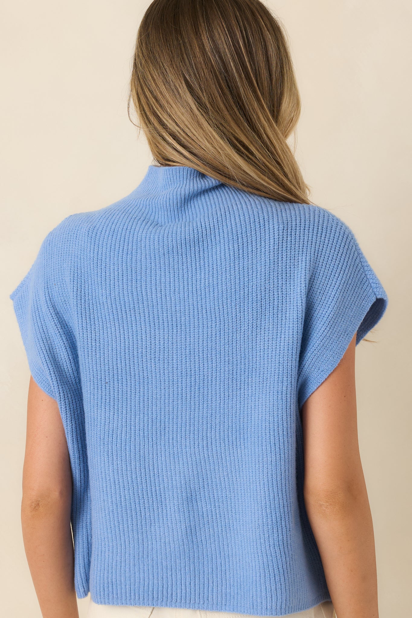 Rear view of the blue ribbed knit top showcasing the smooth back design, relaxed fit, and clean hemline.