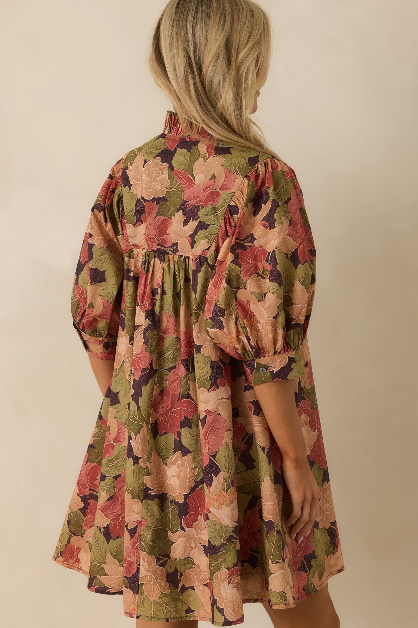 Rear view of brown floral mini dress with half-length puff sleeves and side seam pockets