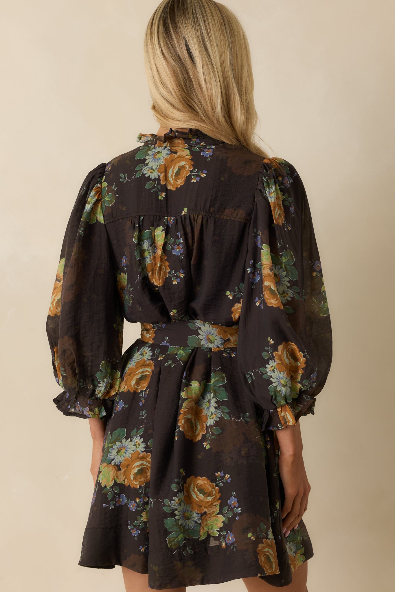 Rear view of the chocolate brown floral mini dress showing the puff sleeves, self-tie waist, and relaxed fit silhouette.