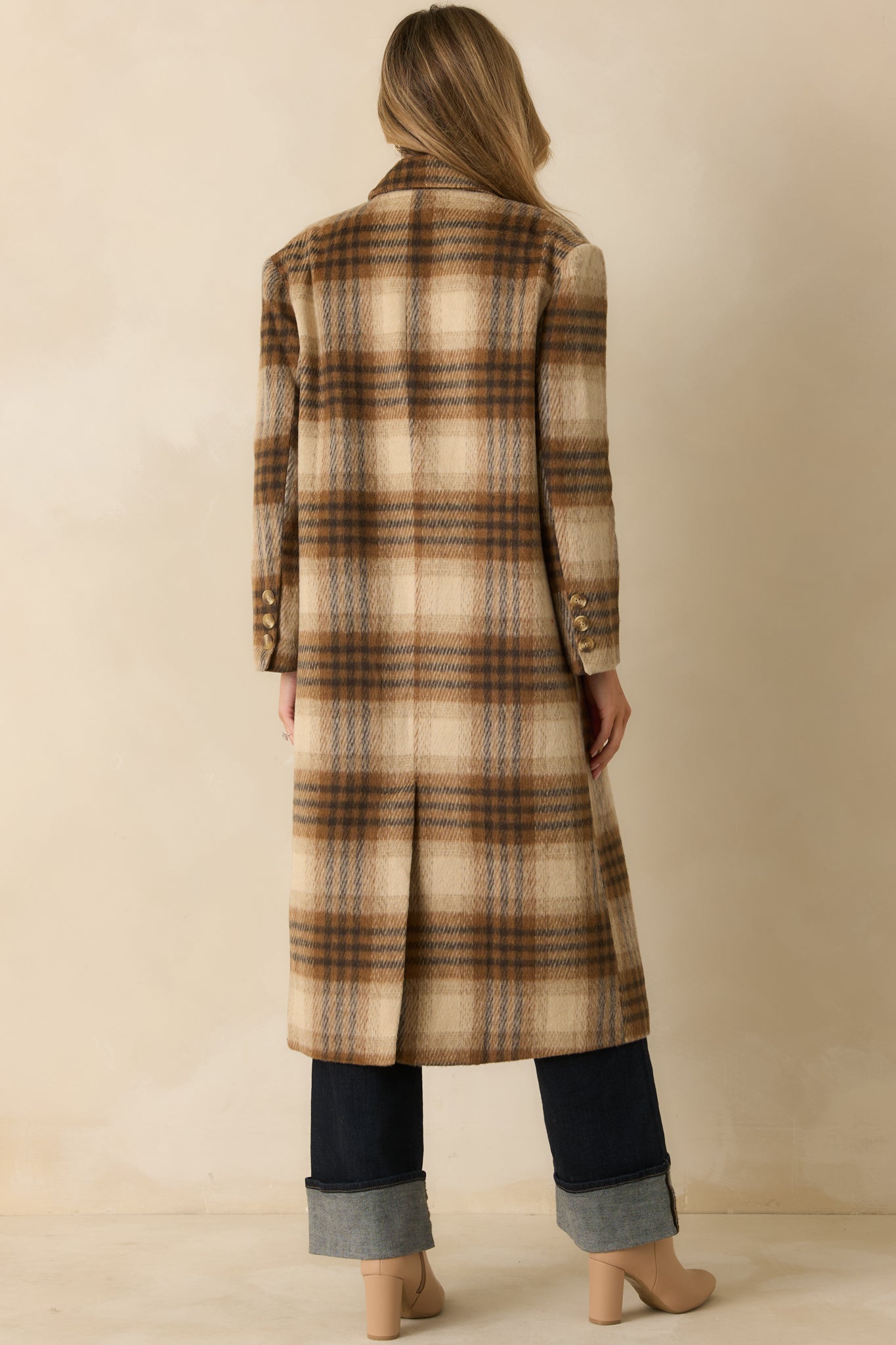 Rear view of the brown plaid overcoat showing the longline silhouette and smooth drape of the fabric.