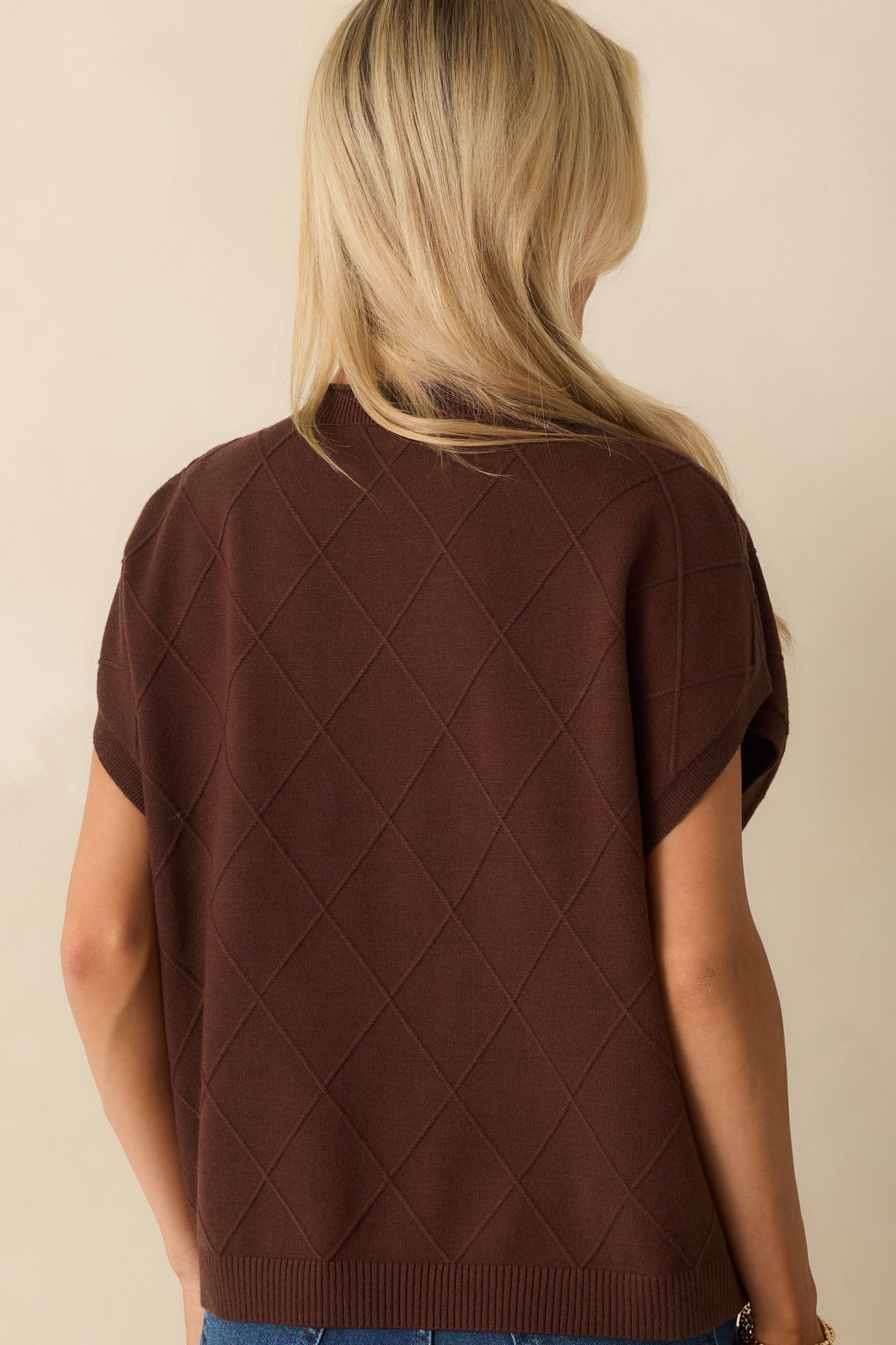 Rear view of brown sweater highlighting dolman sleeves, argyle texture, and straight hem.
