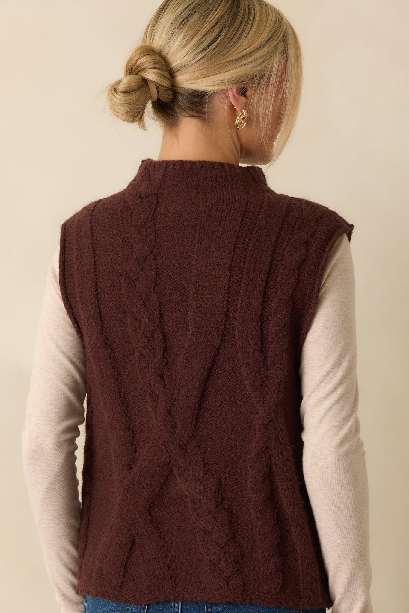 Rear view of the brown sweater vest showing the relaxed fit and smooth cable knit finish.