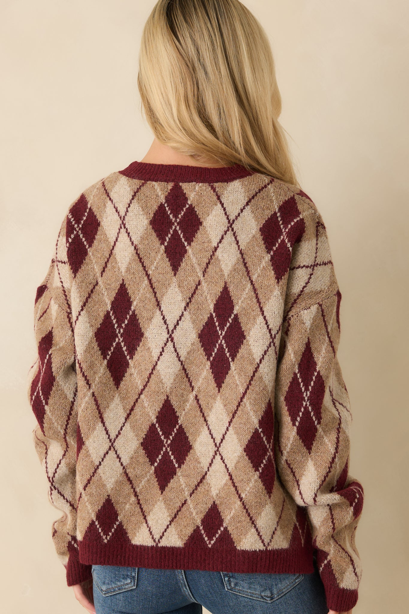 Rear view of the burgundy argyle sweater showing relaxed fit and clean knit finish.
