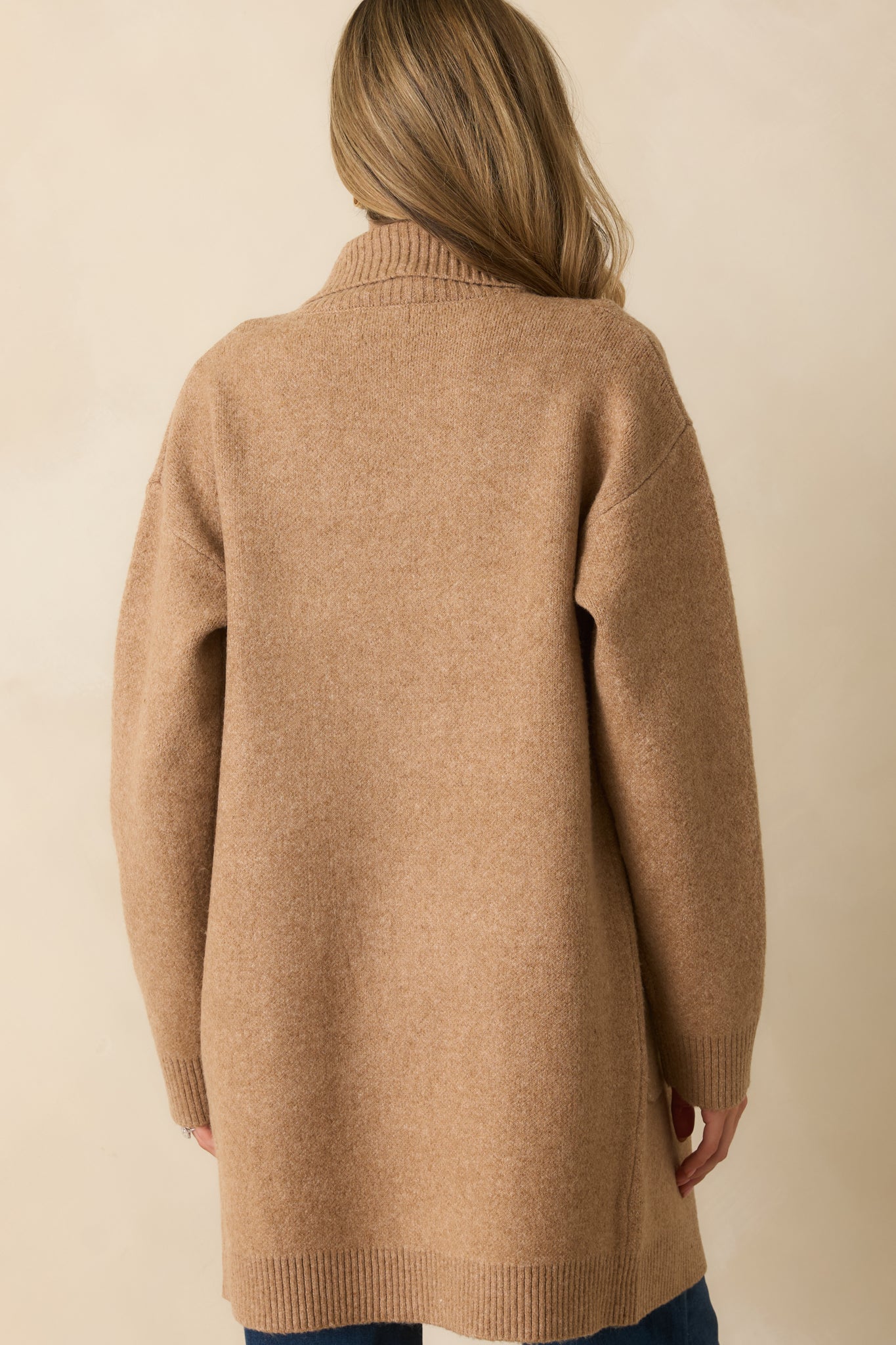 Rear view of camel brown cardigan with drop shoulders, long sleeves, and ribbed hemline.