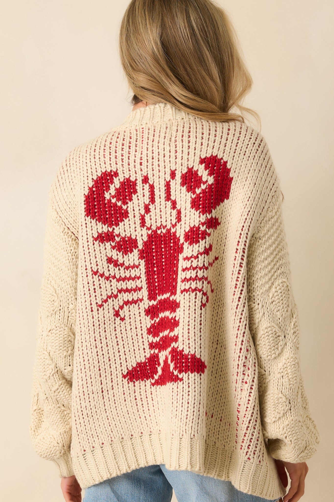 Rear view of the cardigan showcasing the large red lobster knit motif across the back.