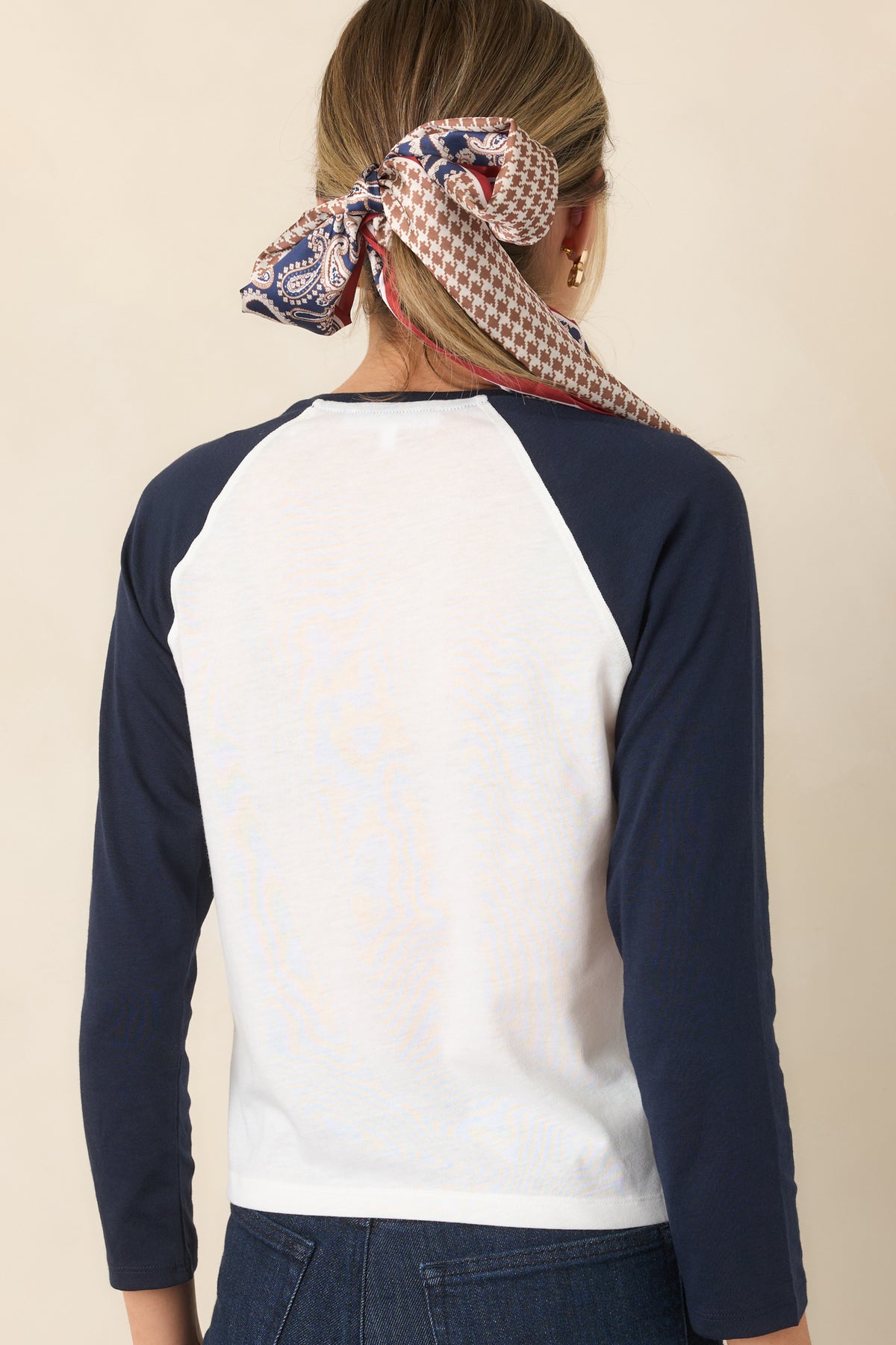 Rear view of the chalk white top with contrasting navy raglan sleeves.