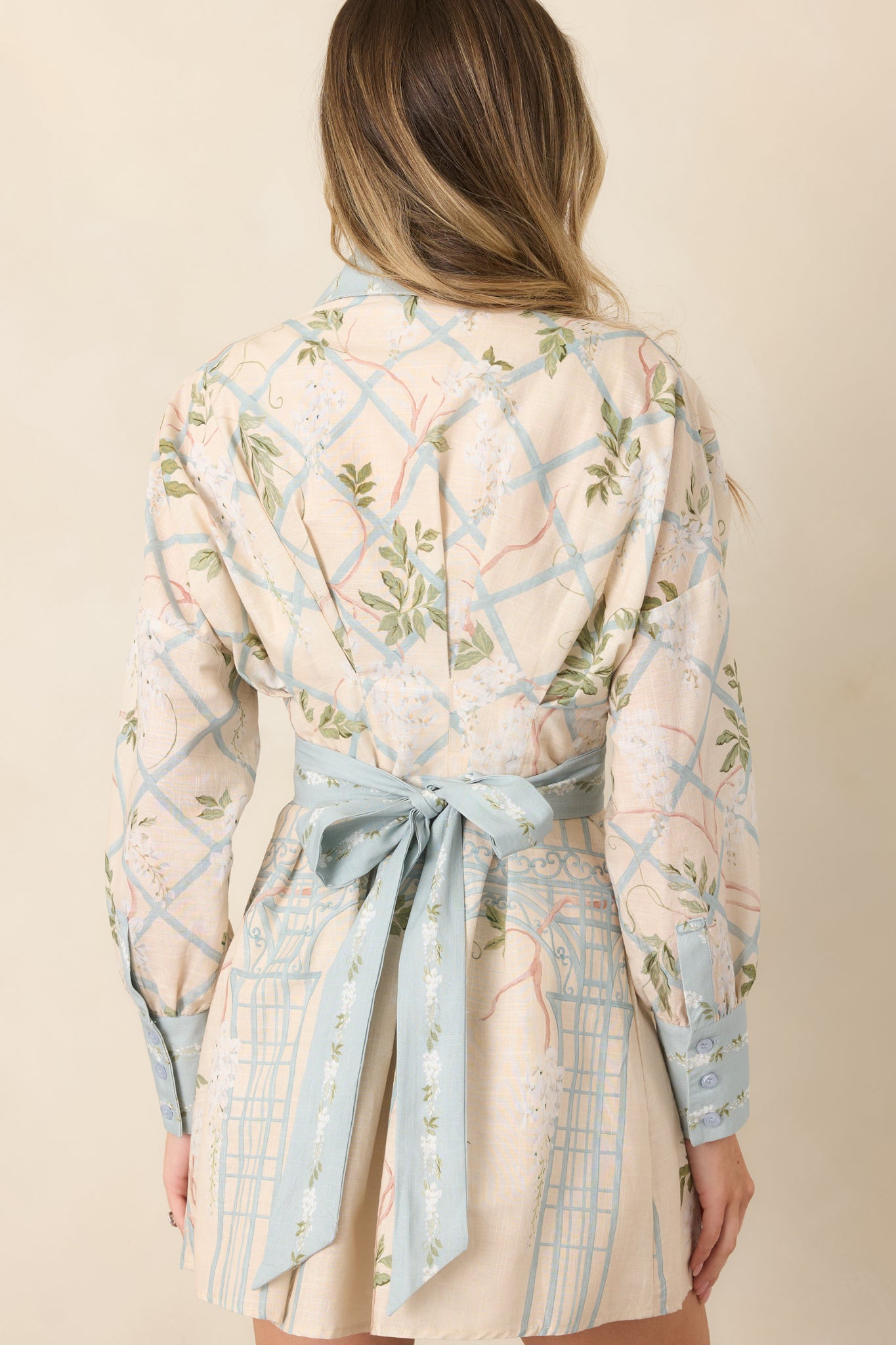 Rear view of the collared mini shirt dress showcasing its defined waist, long sleeves with button cuffs, and streamlined tailored silhouette.