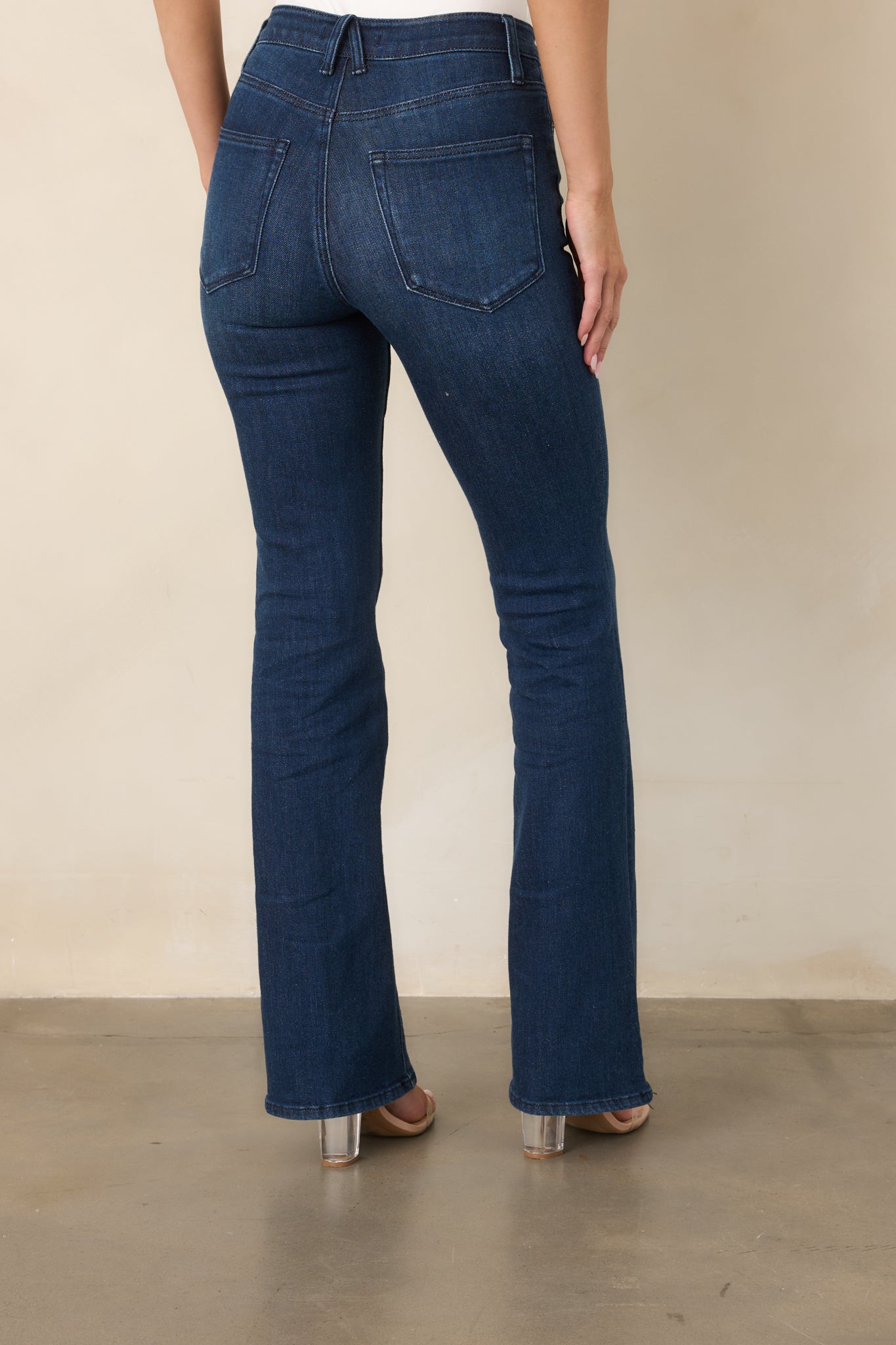 Rear view of the dark wash bootcut jeans showcasing the high-rise waist, back pockets, streamlined fit, and subtly flared legs.