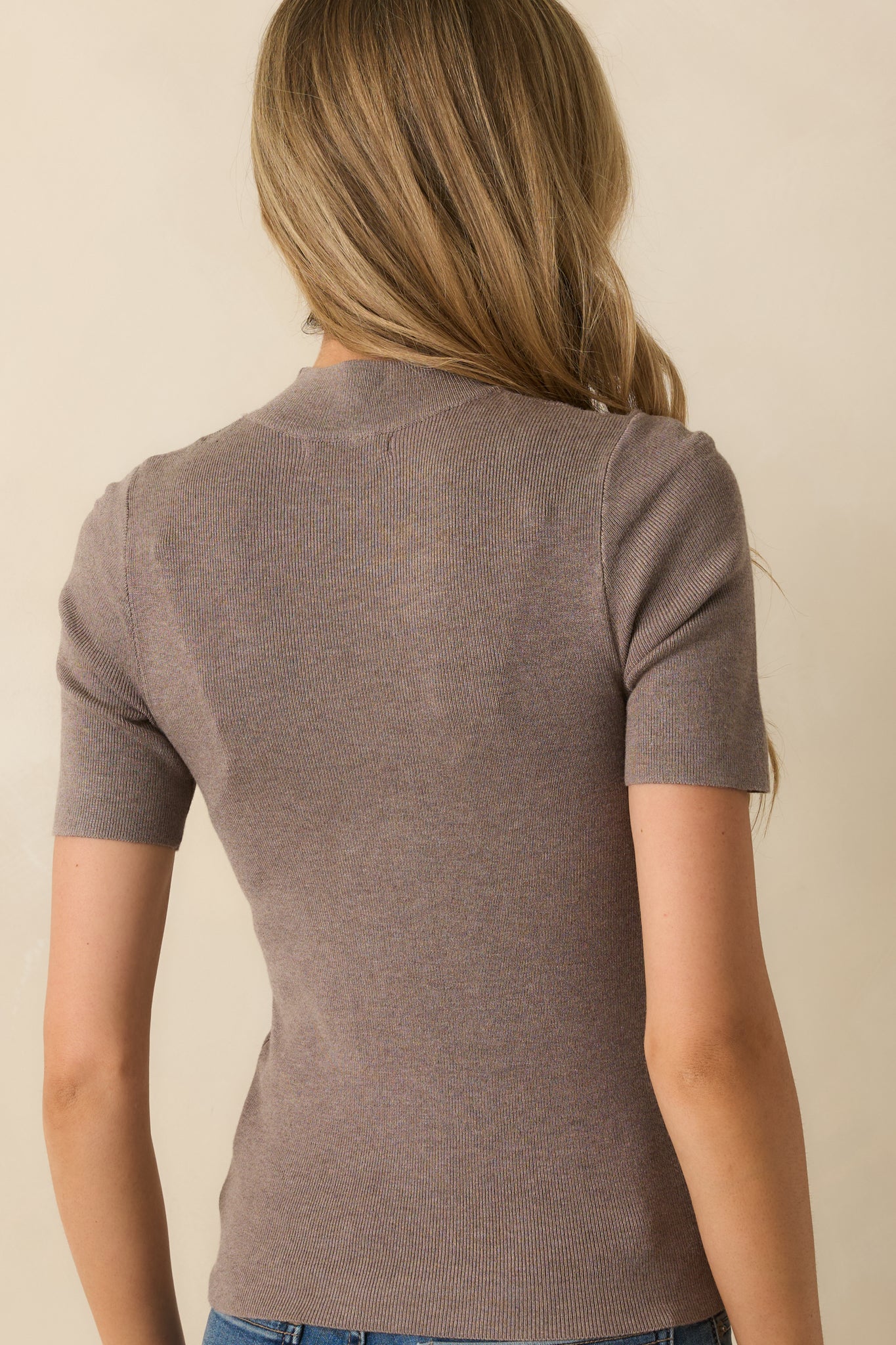 Rear view of the dark taupe top showing smooth knit back and short sleeves.