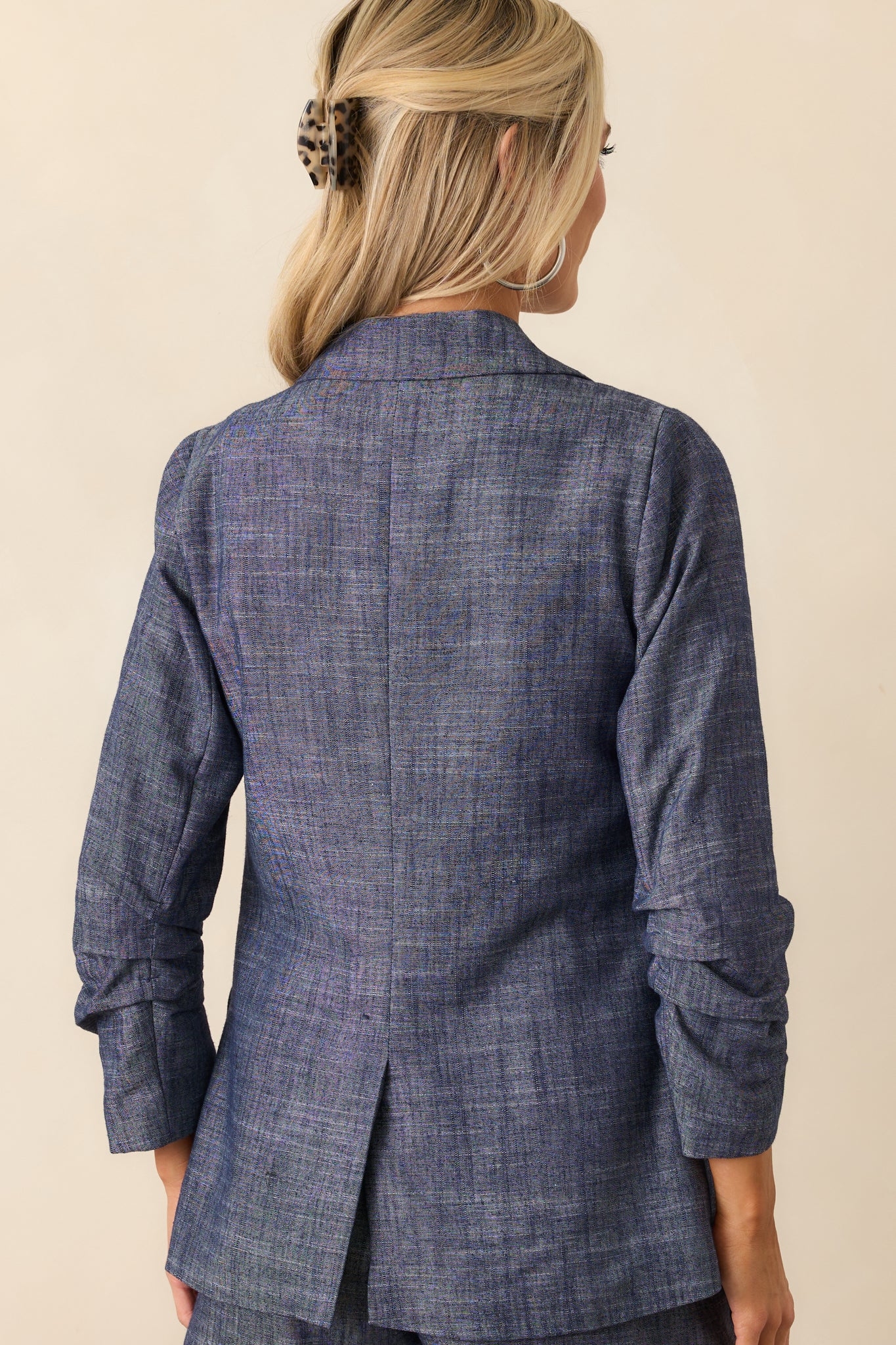 Rear view of blazer displaying clean back panel construction and subtle structure in the lightweight fabric.