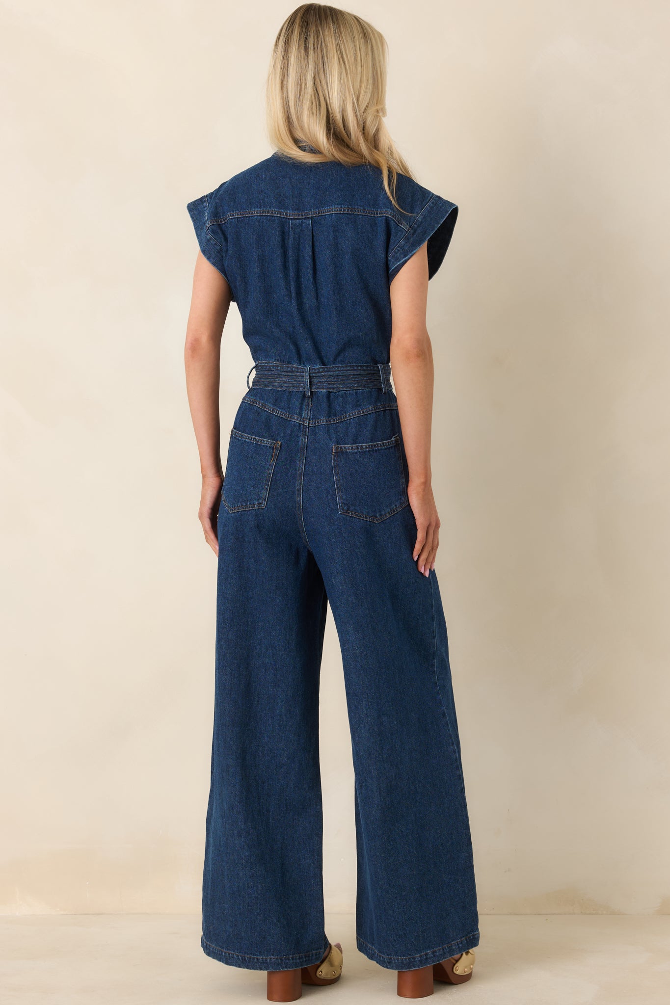 Rear view of the jumpsuit displaying the cap sleeves, wide-leg shape, and defined waistline.