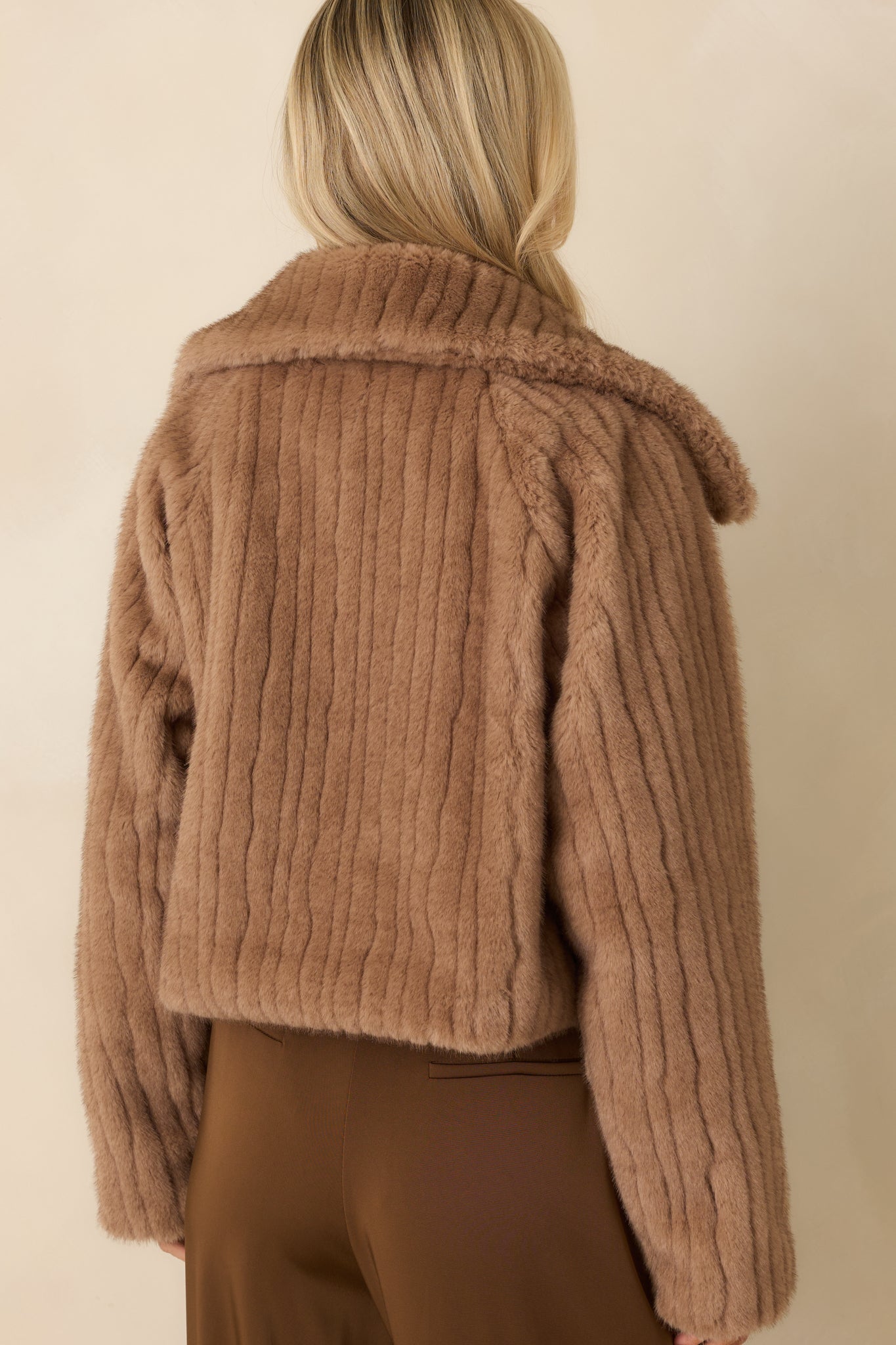 Rear view of the mocha brown faux fur jacket displaying the ribbed texture, relaxed cropped length, and smooth lined finish.
