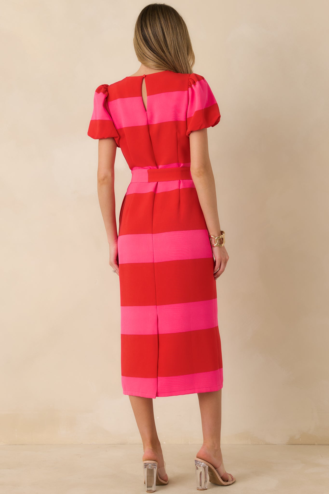 Rear view of the red and pink striped midi dress featuring a keyhole button closure and back slit.