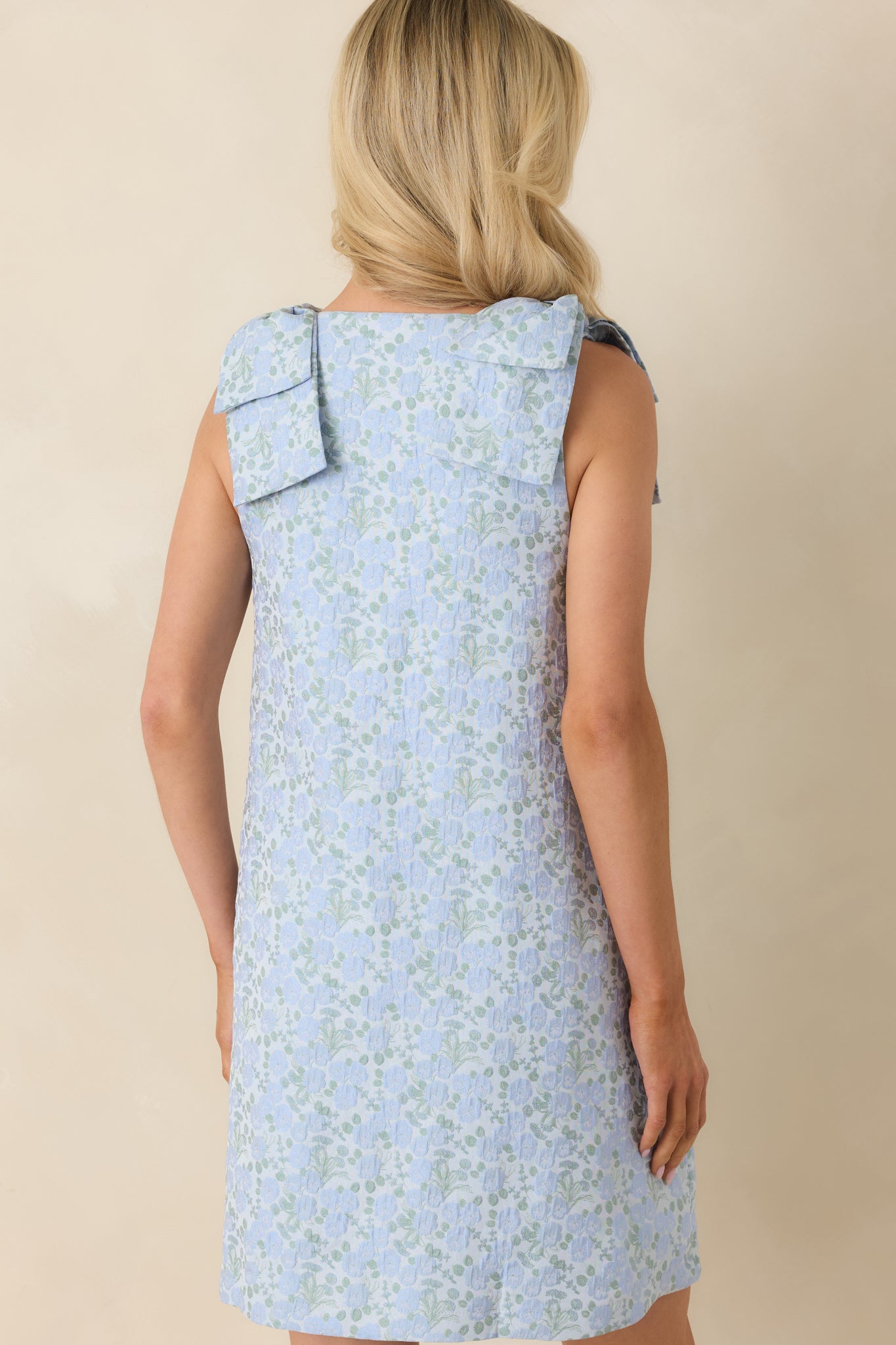 Rear view of the light blue mini shift dress featuring a sleeveless silhouette and relaxed flowing fit.