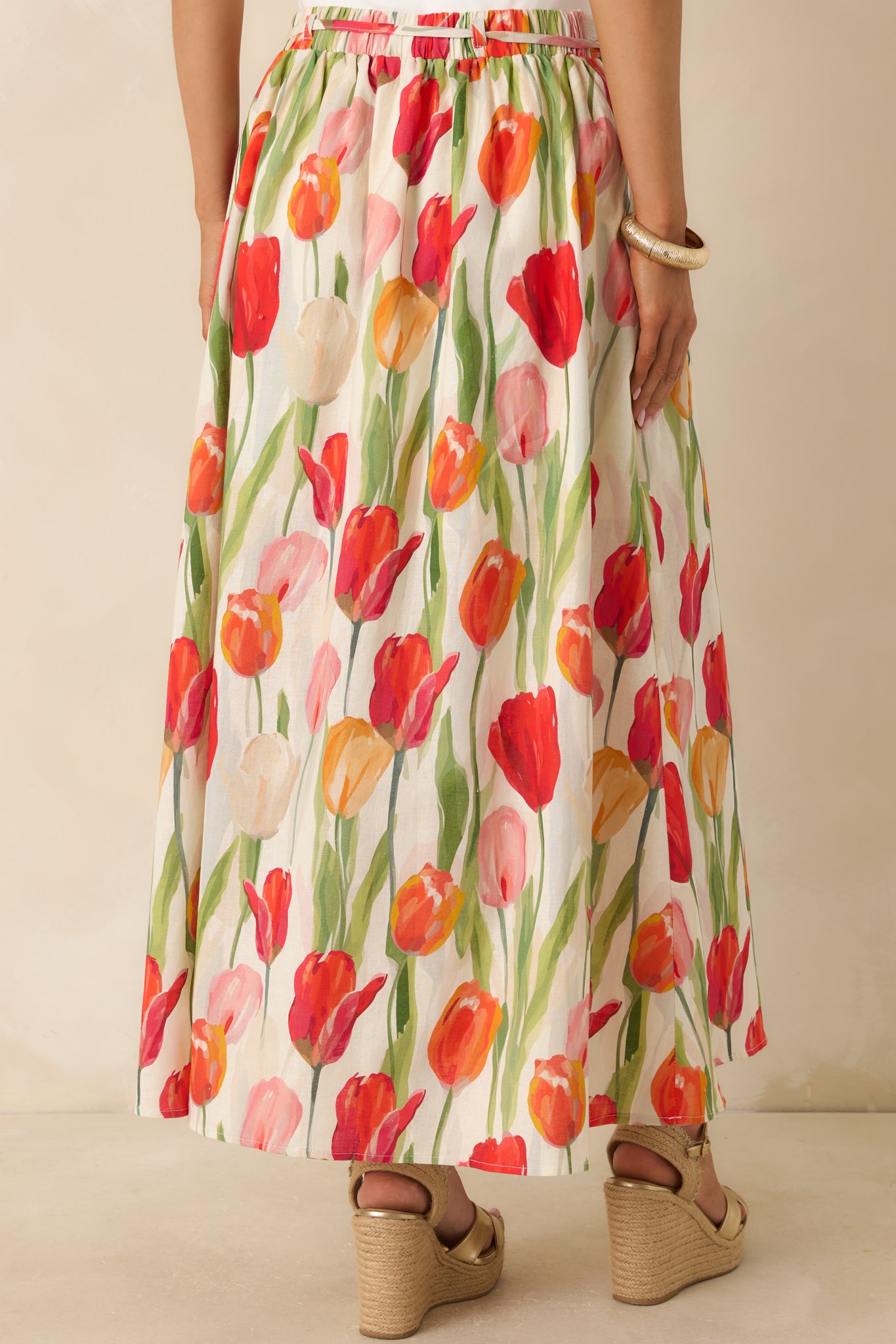 Rear view of the ivory and red floral midi skirt featuring the flowy silhouette, elastic waistband, and soft tulip print throughout.