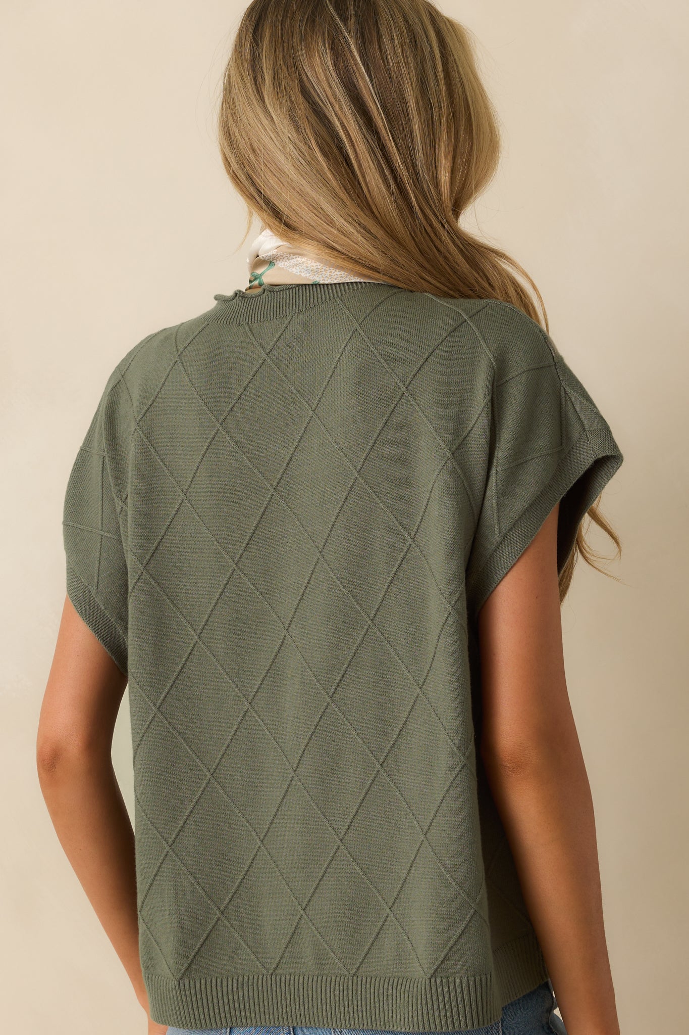 Rear view of the green sweater highlighting dolman sleeves, argyle texture, and straight hem.