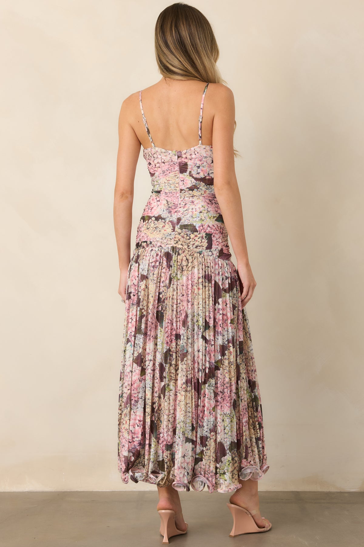Rear view of the hydrangea floral maxi dress showcasing the adjustable spaghetti straps, fitted ruched bodice, gathered skirt, and distinctive wavy hemline.