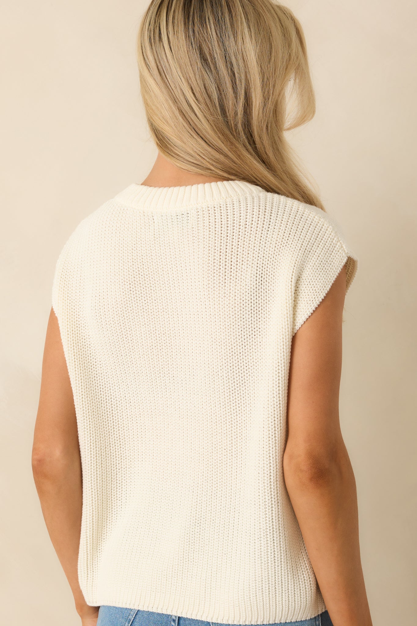 Rear view of the ivory knit tank showing boxy silhouette, cap sleeves, and ribbed hem.