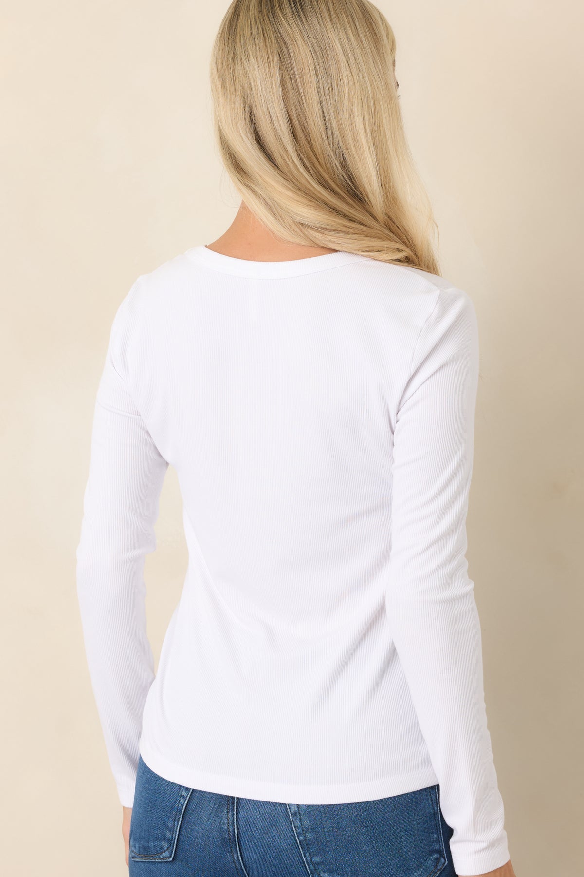 Rear view of the ivory top showcasing its long sleeves, slightly relaxed silhouette, and clean back design.