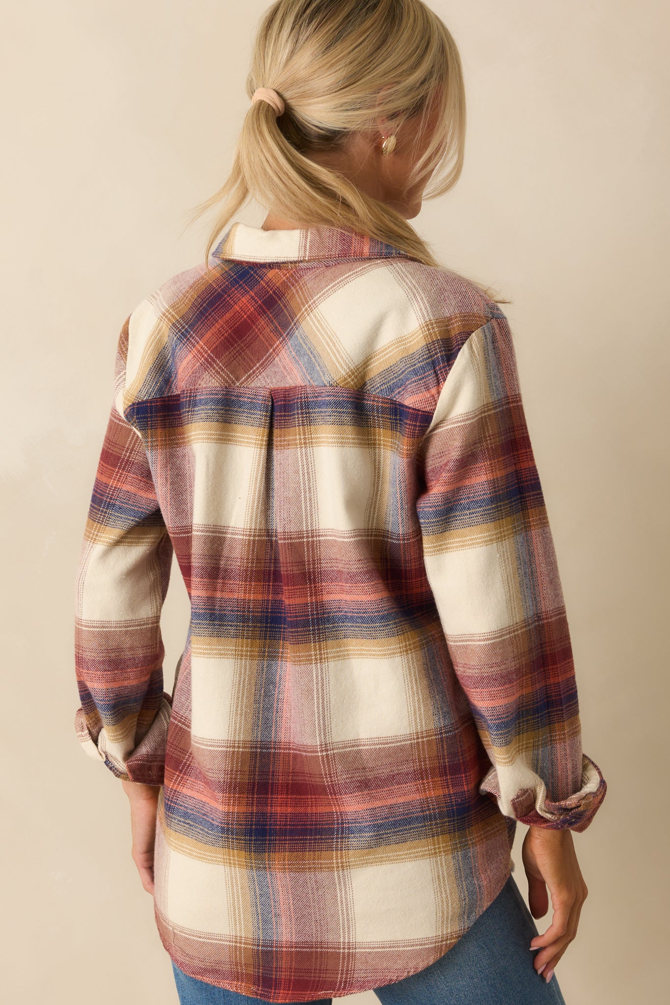 Rear view of ivory plaid shirt highlighting back yoke with box pleat, long sleeves, and scoop hem.