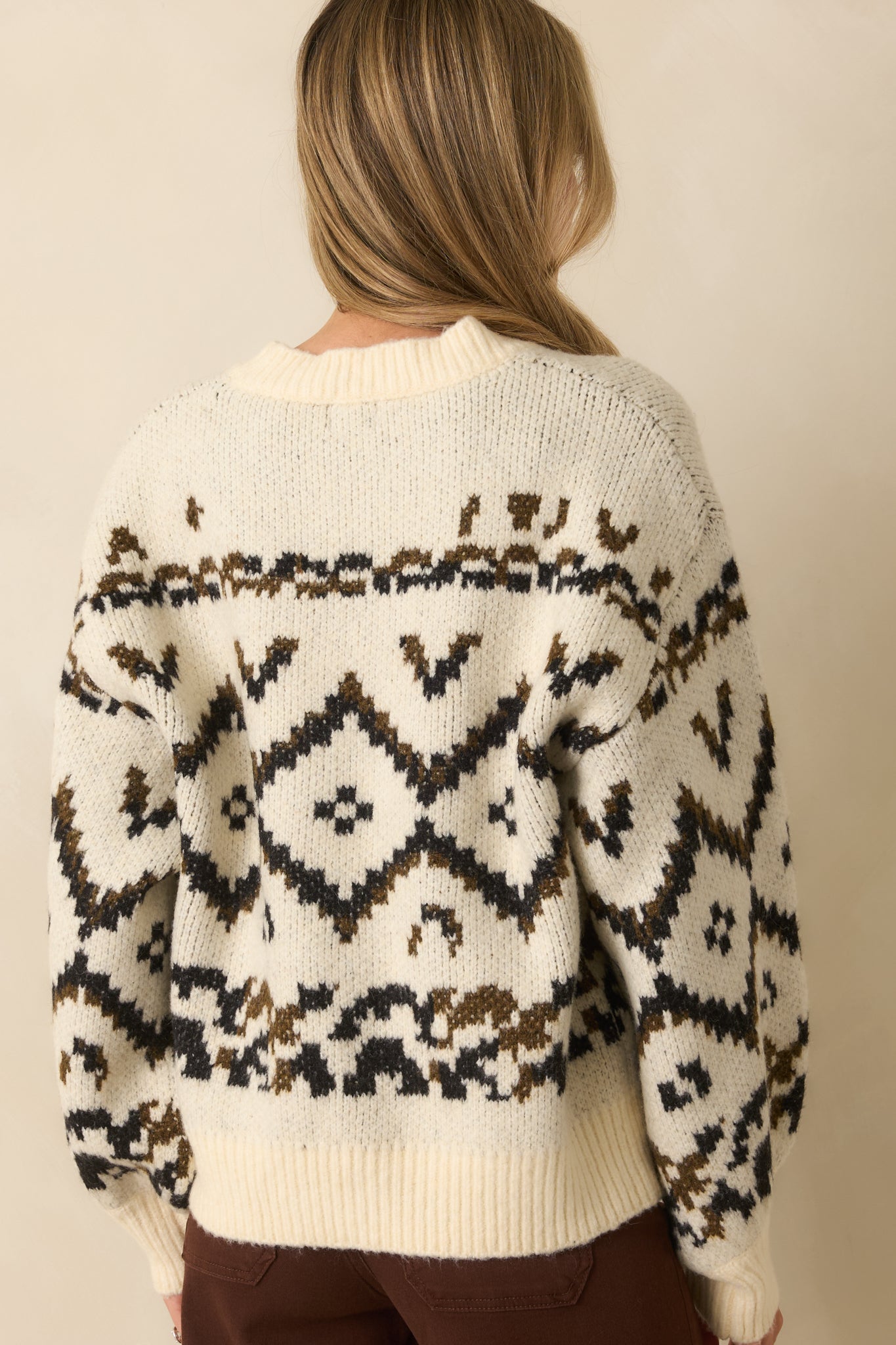 Rear view of the ivory sweater showing dropped shoulders and ribbed trim finish.