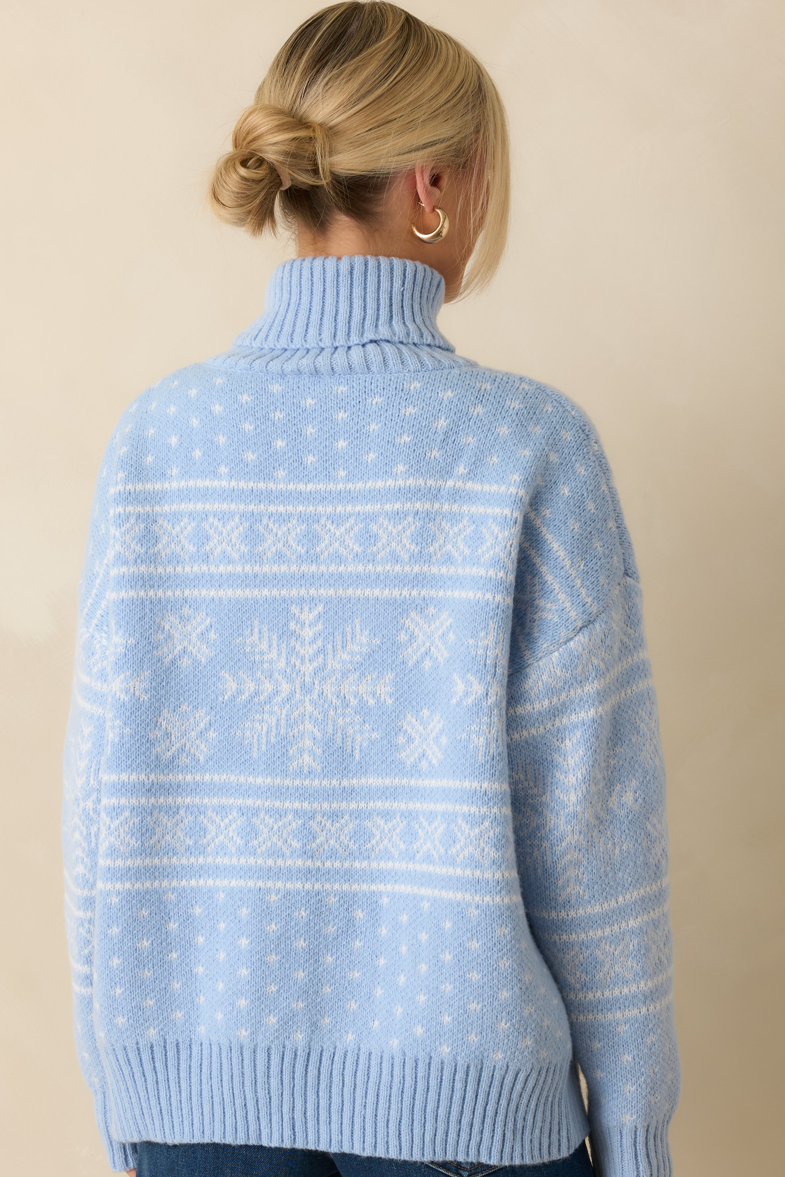 Rear view of the light blue knit turtleneck sweater showing the smooth, relaxed fit and soft knit finish.