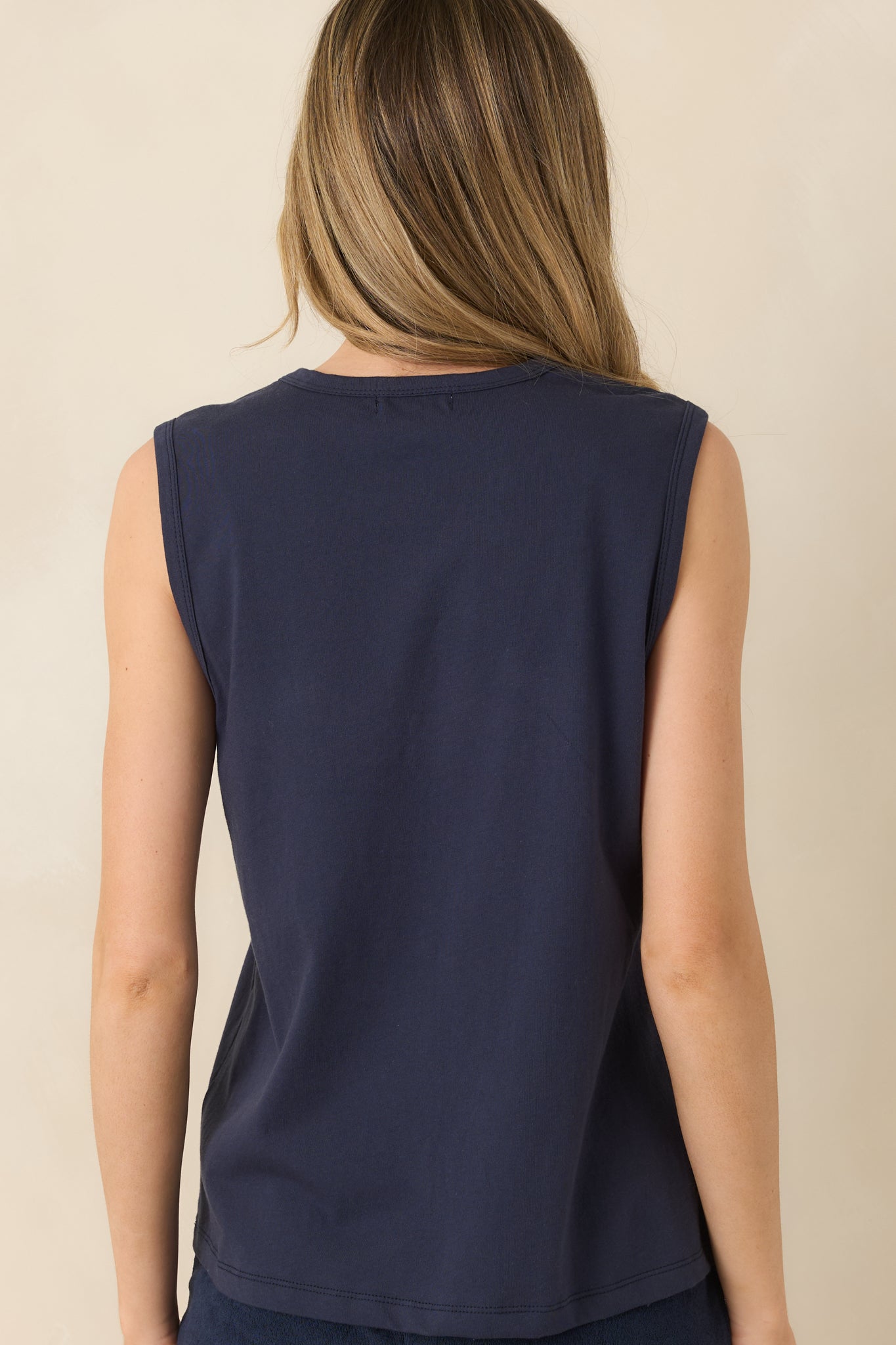 Rear view of sleeveless muscle tank with crew neckline and relaxed, casual fit.