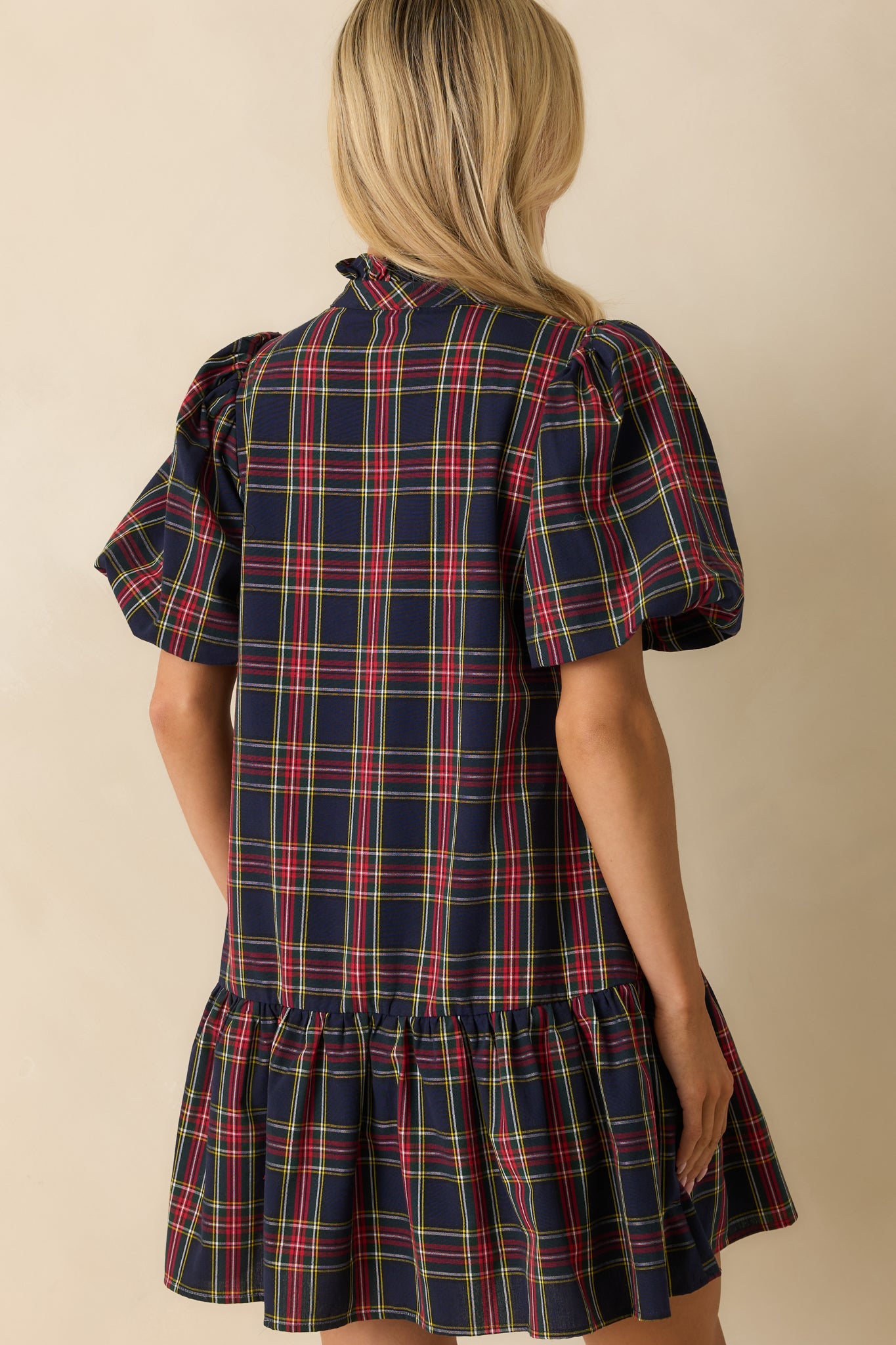 Rear view of navy plaid mini dress showing short puff sleeves, relaxed fit, and fully lined woven back.