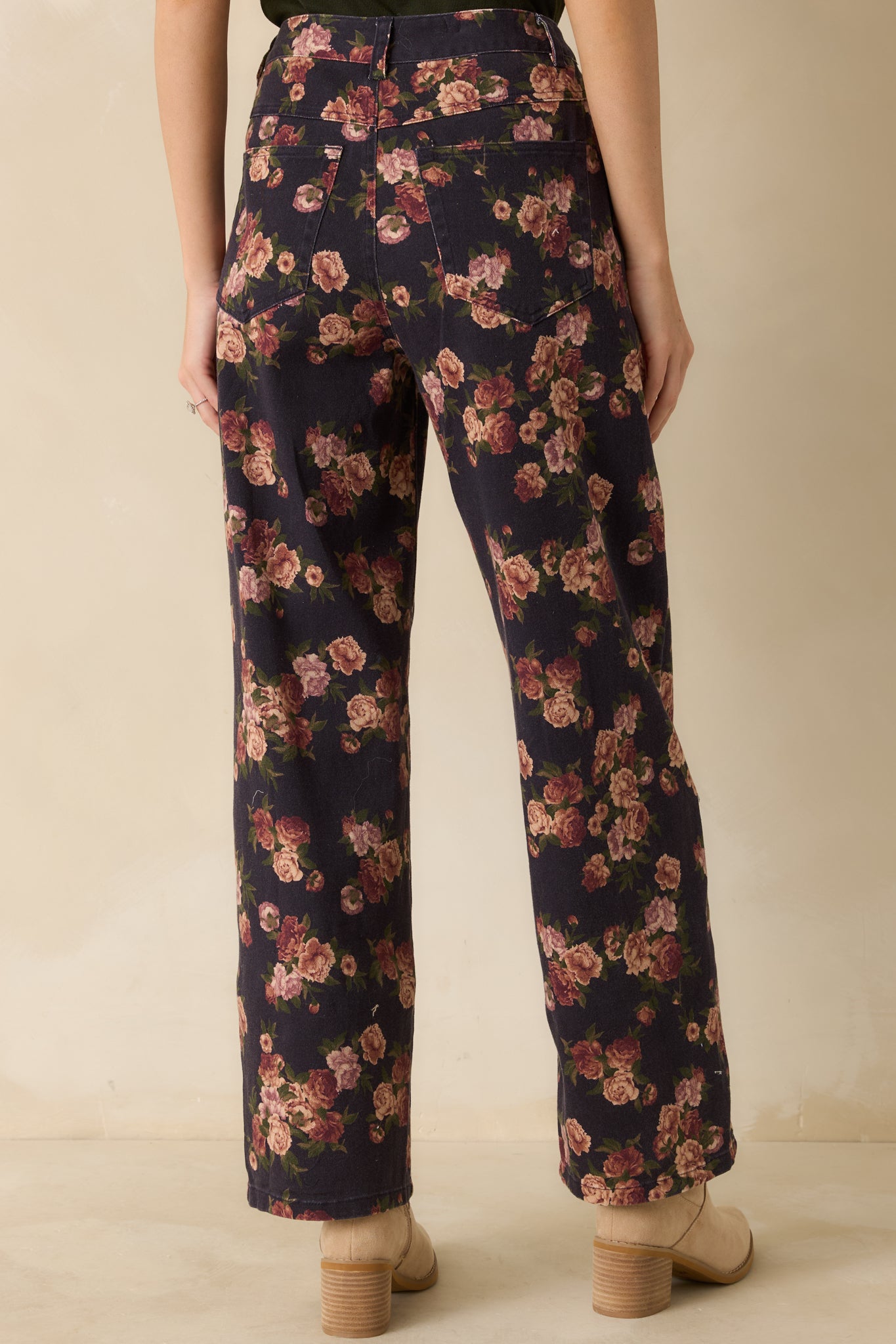 Rear view of navy straight-leg jeans showing back pockets and full coverage of the floral print.