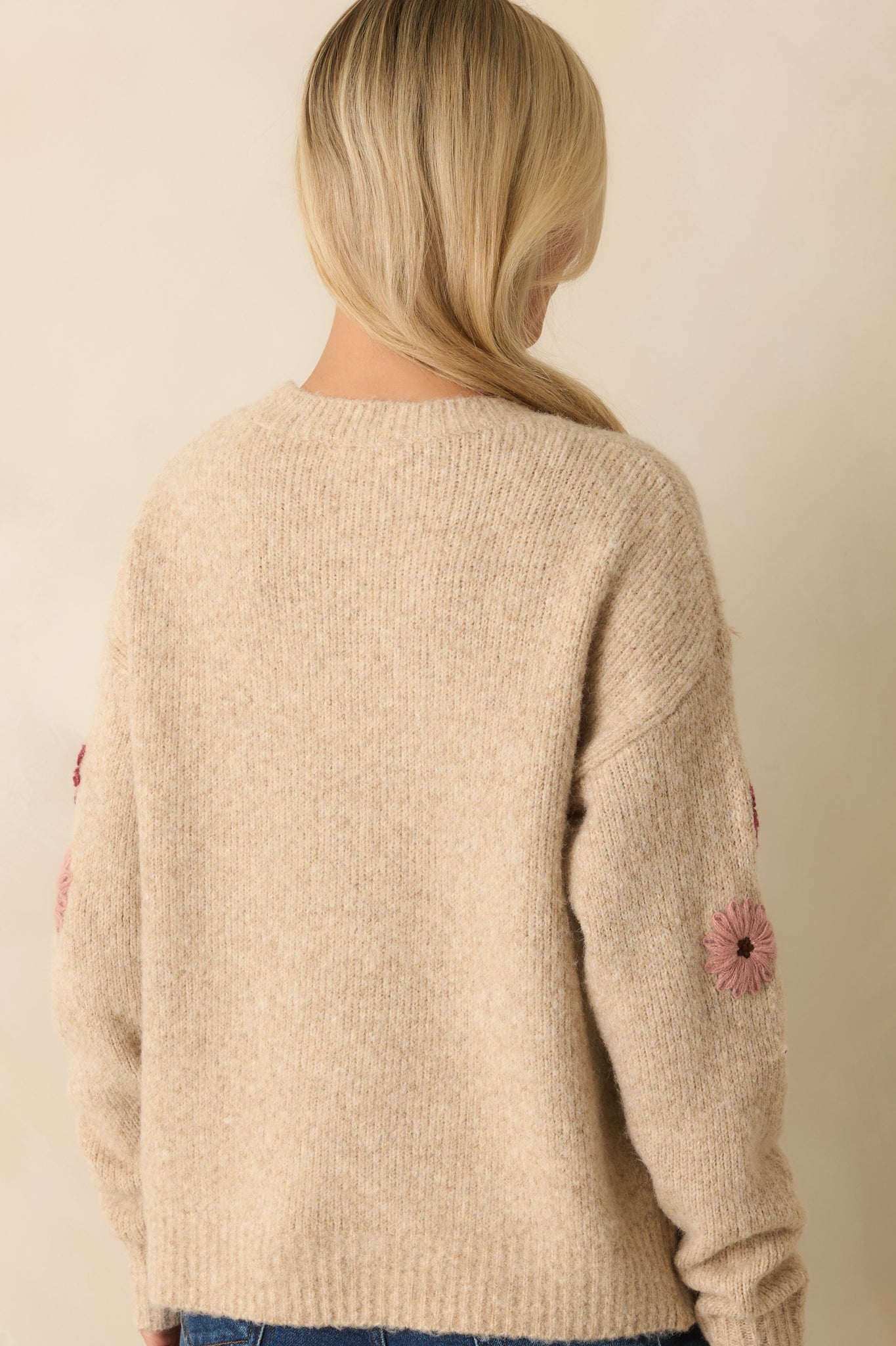 Rear view of the oatmeal sweater showing the relaxed fit, long sleeves, and subtle continuation of textured knit.