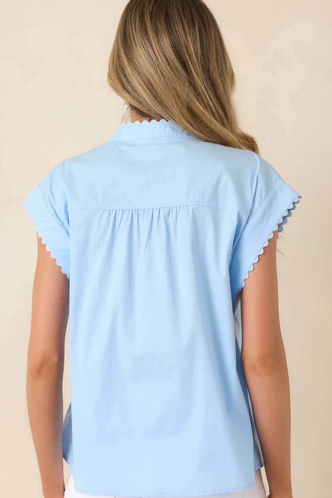 Rear view of blouse with relaxed fit and clean cap sleeve finish