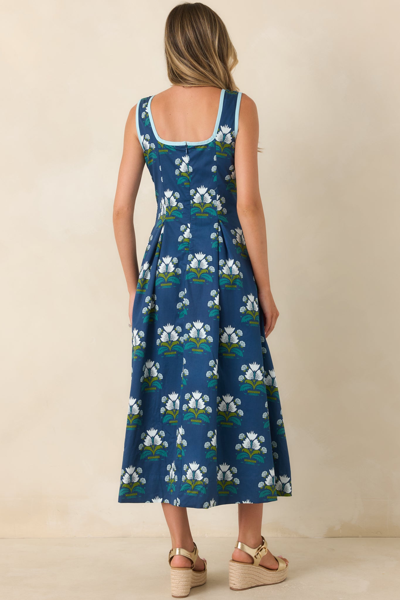 Rear view of the blue floral dress showcasing the concealed zipper and flowing A-line silhouette.