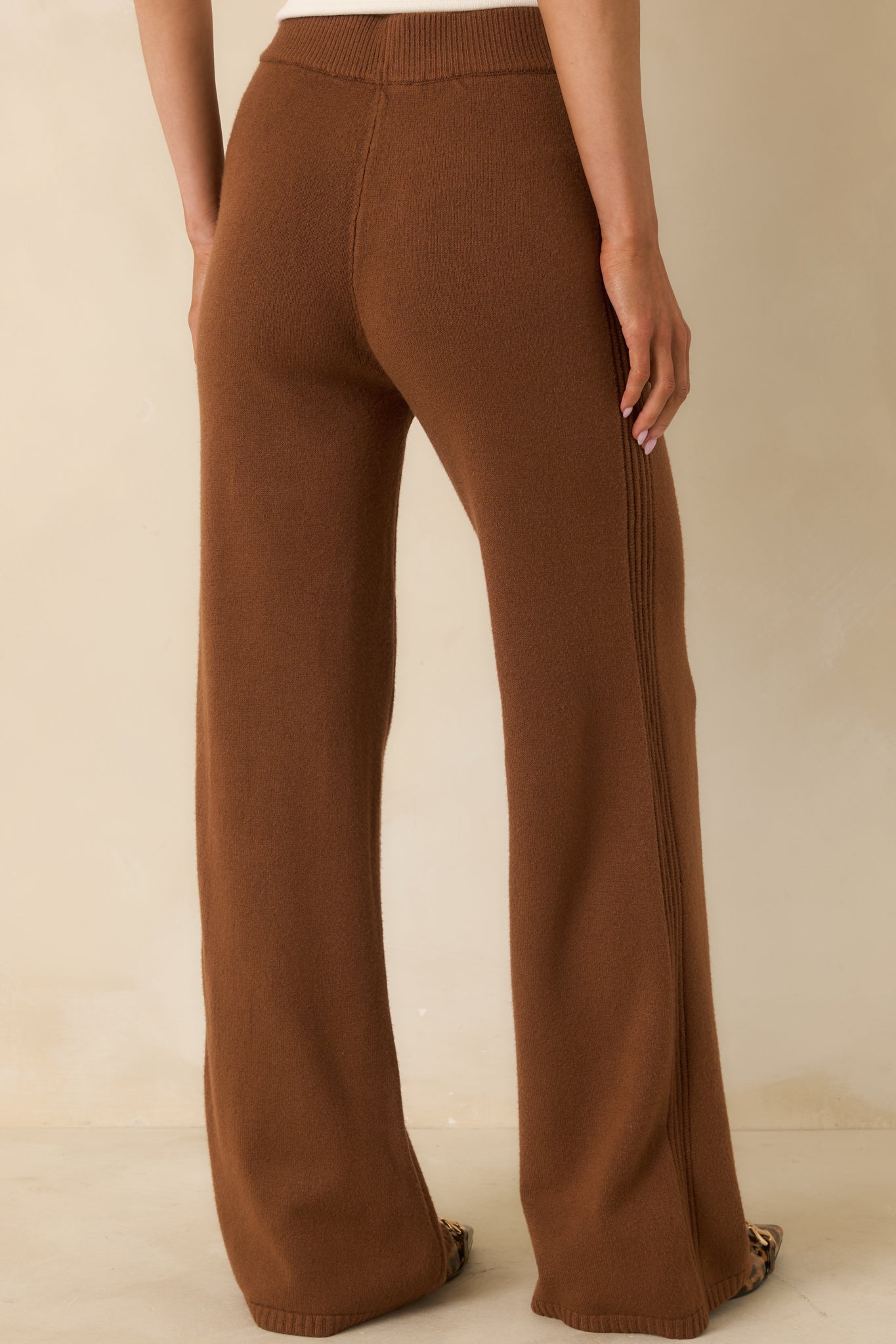Rear view of brown knit pants showing wide-leg fit and relaxed pull-on silhouette.