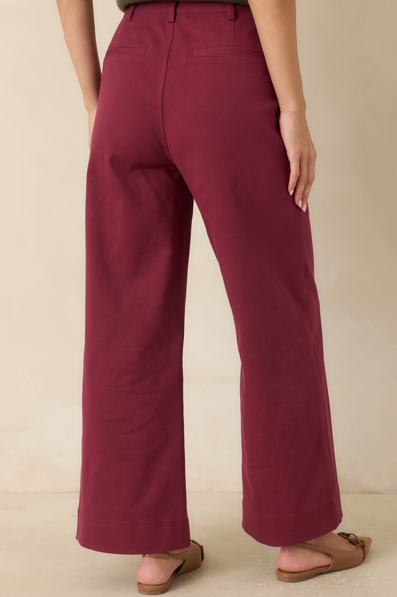 Rear view of the burgundy wide-leg pants showcasing the clean back design, belt loops, and tailored silhouette.