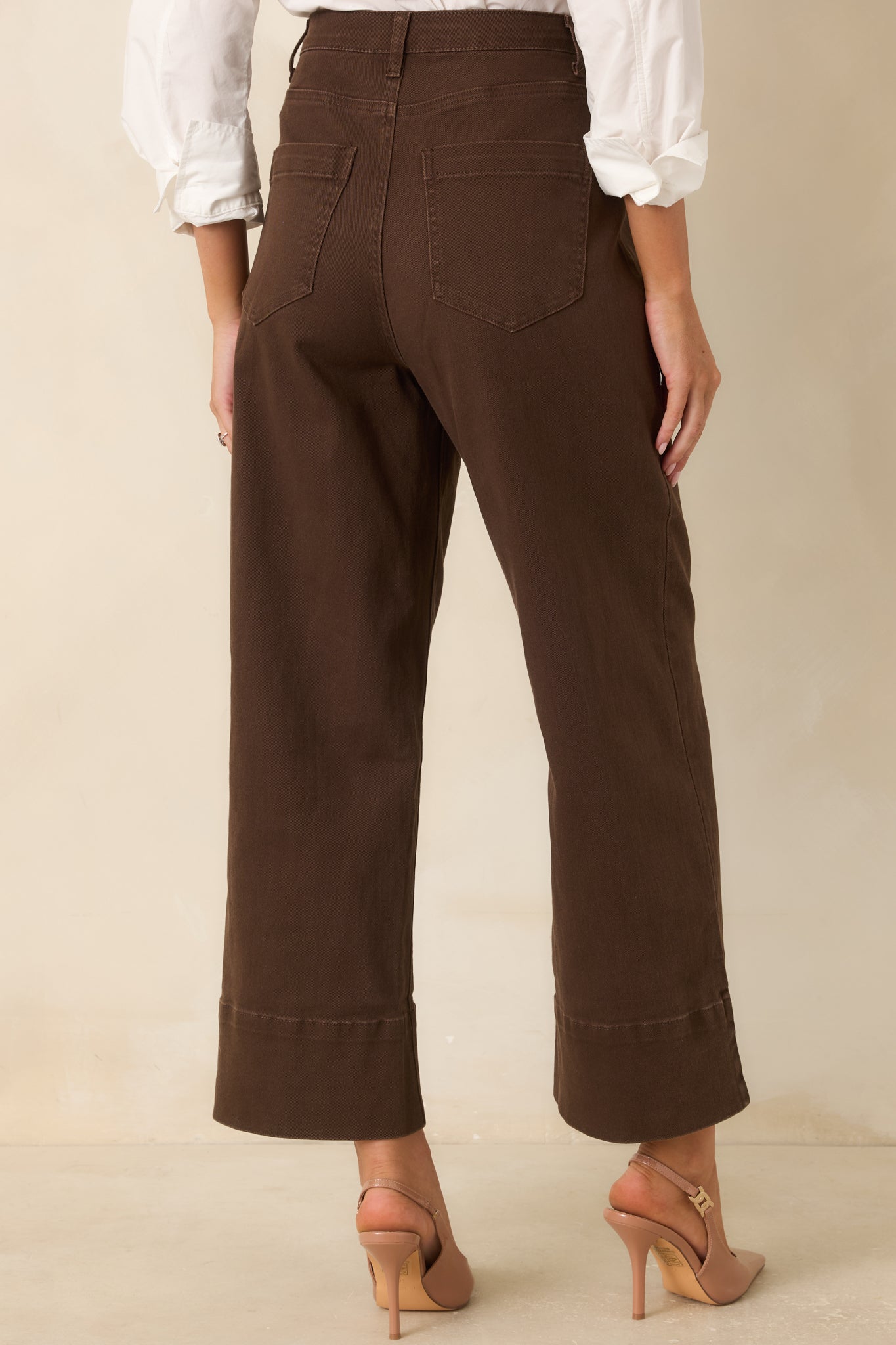 Rear view of the chocolate cropped pants featuring classic back patch pockets, belt loops, and a structured wide-leg shape.