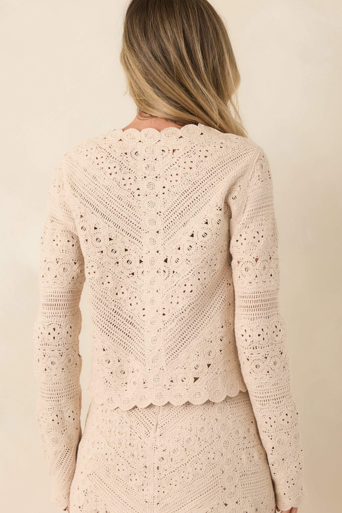 Rear view of the cardigan showcasing the intricate crochet texture and slightly cropped silhouette.