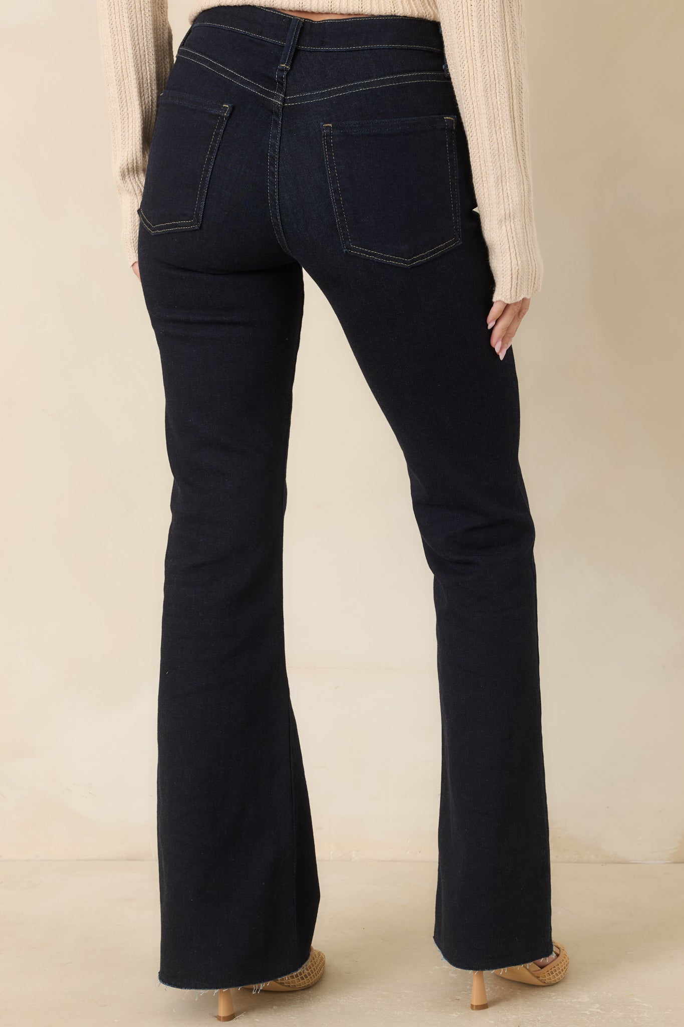 Rear view of the dark indigo jeans showcasing the back pockets and dramatic flared legs.