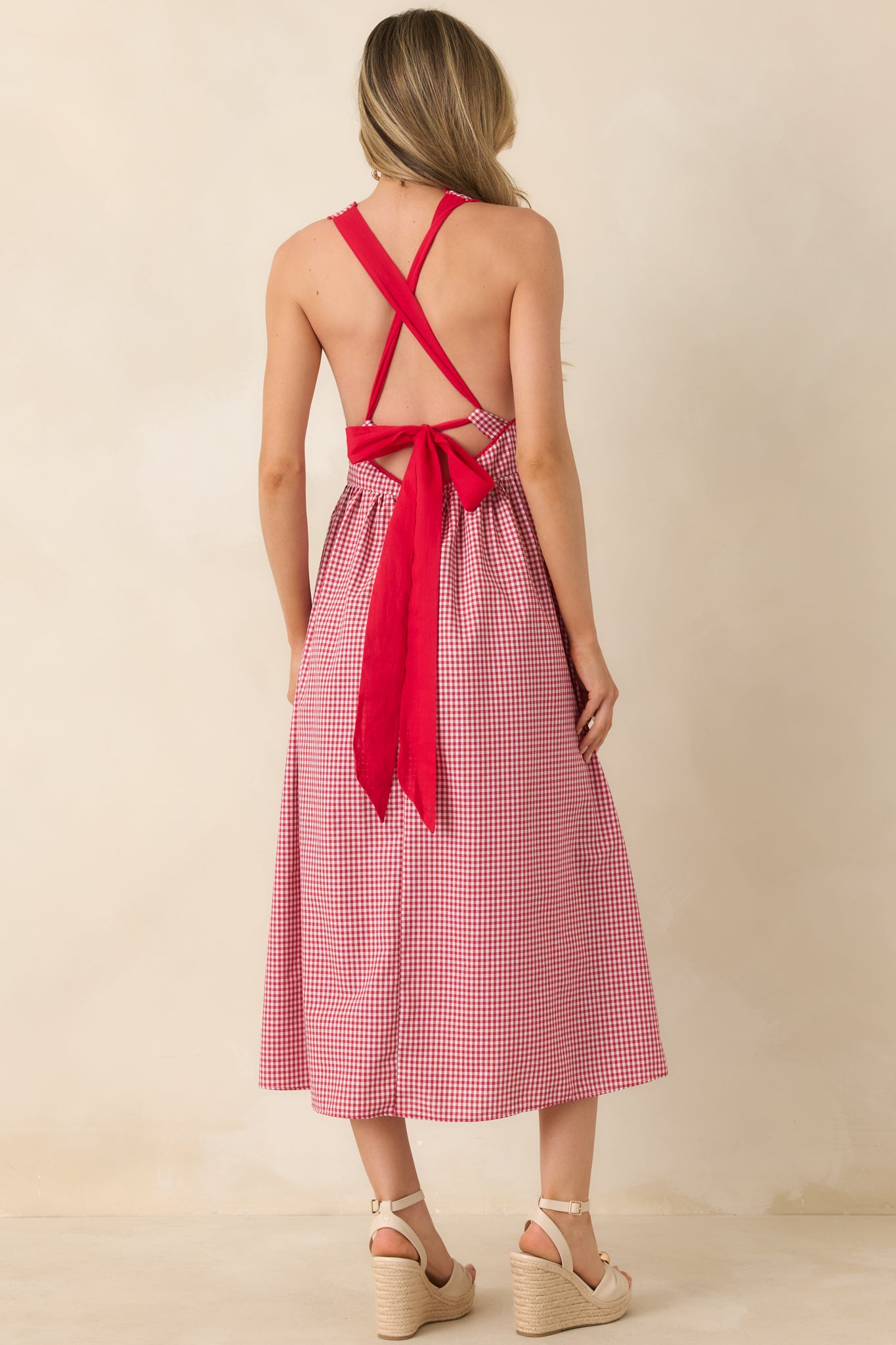 Rear view of dress with open back, crisscross straps, and oversized bow detail.