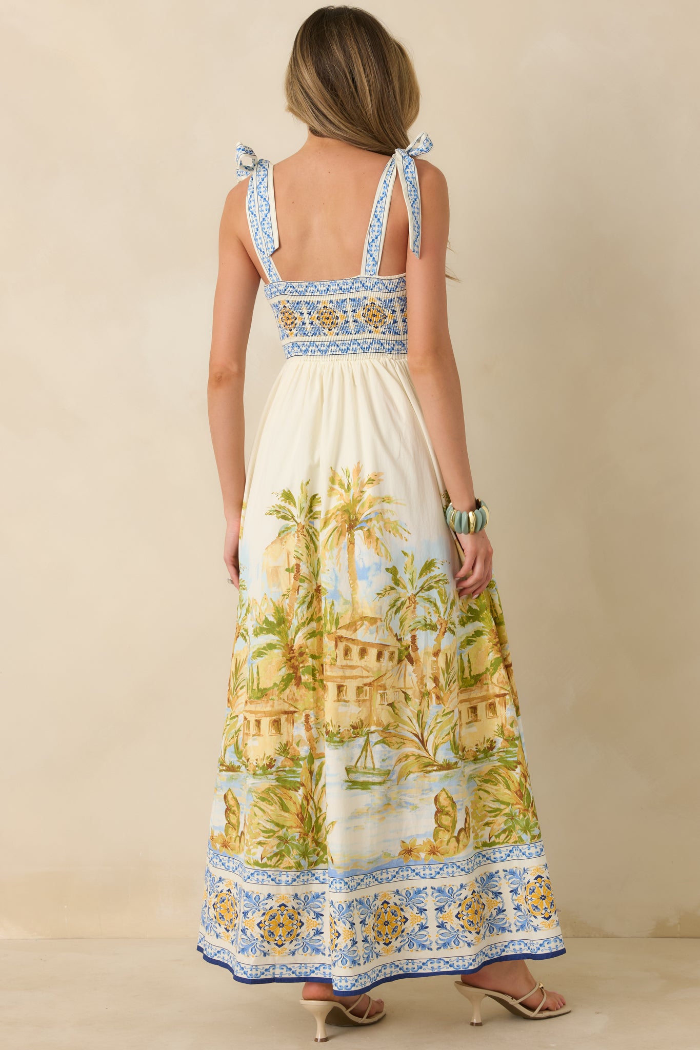 Rear view of ivory multi maxi dress with adjustable tie straps and flowing full-length skirt.
