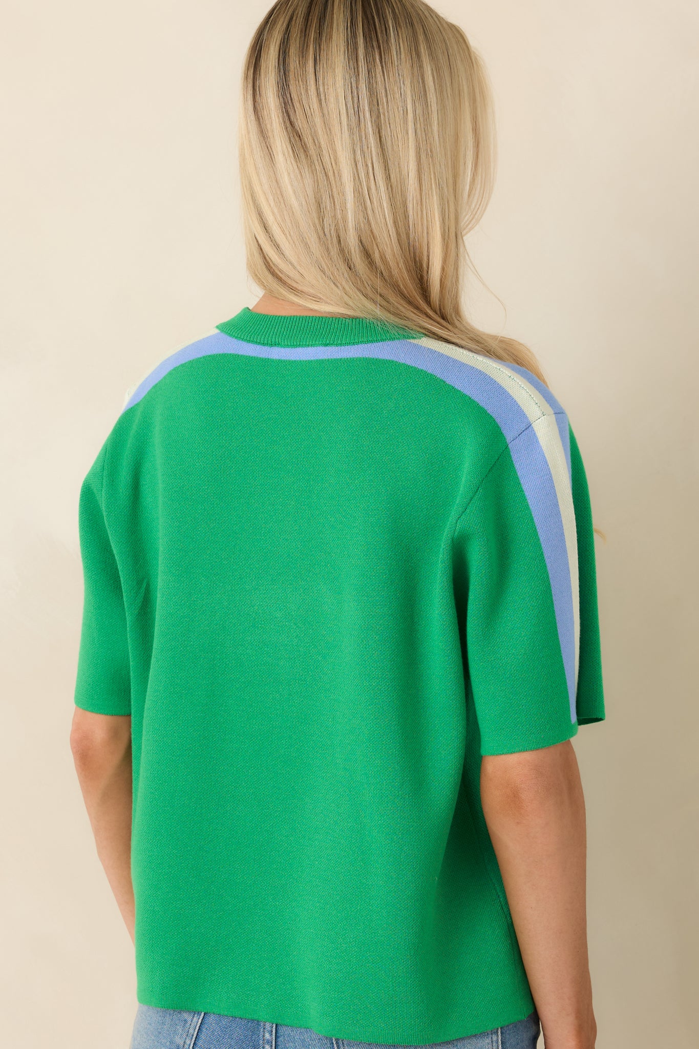 Rear view of green knit top with relaxed fit, short sleeves, and draped shape.
