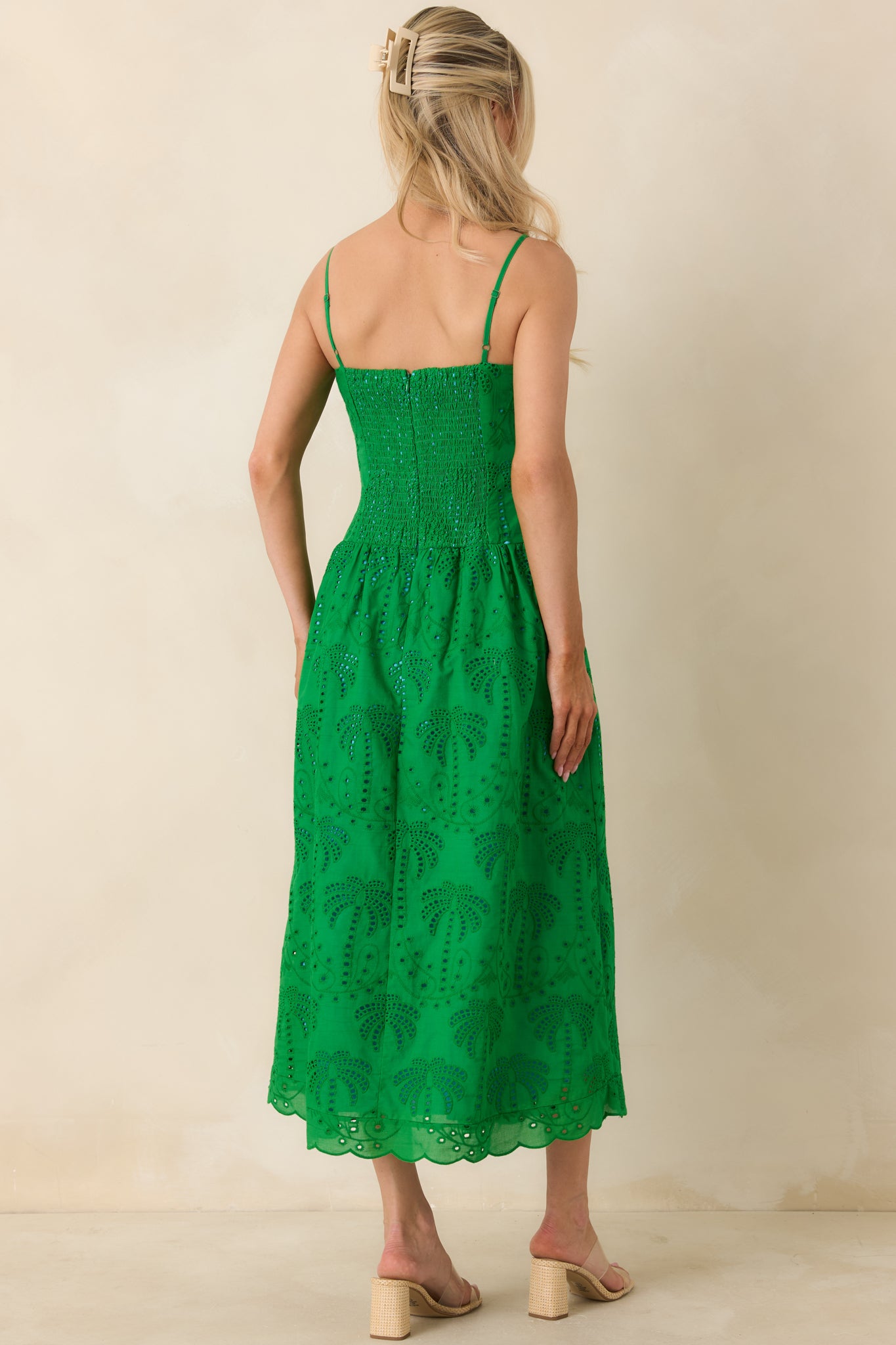 Rear view of green midi dress showing smocked back and adjustable straps.