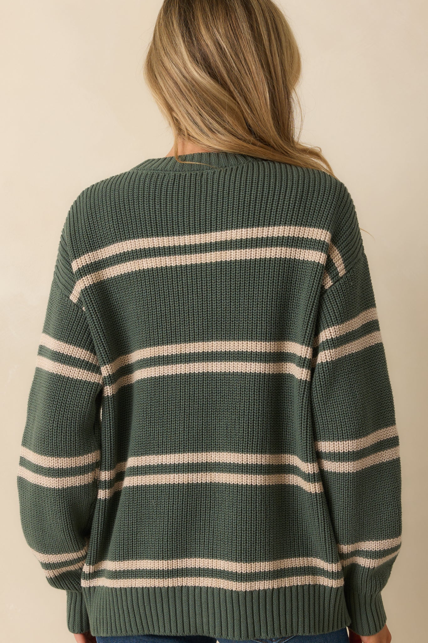 Rear view of the green striped cardigan showing the smooth knit back and ribbed hems.