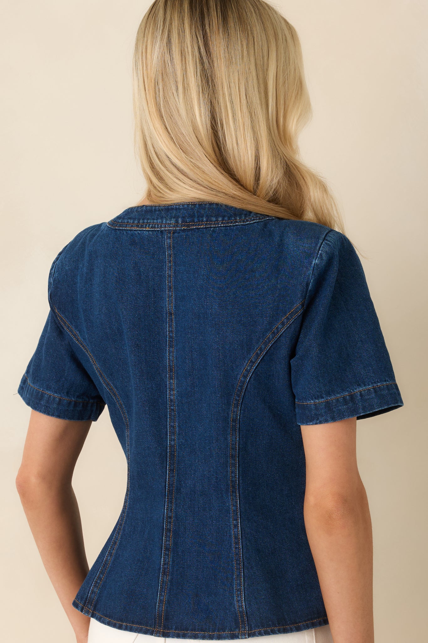 Rear view of indigo denim top with clean, structured seams and fitted shape.